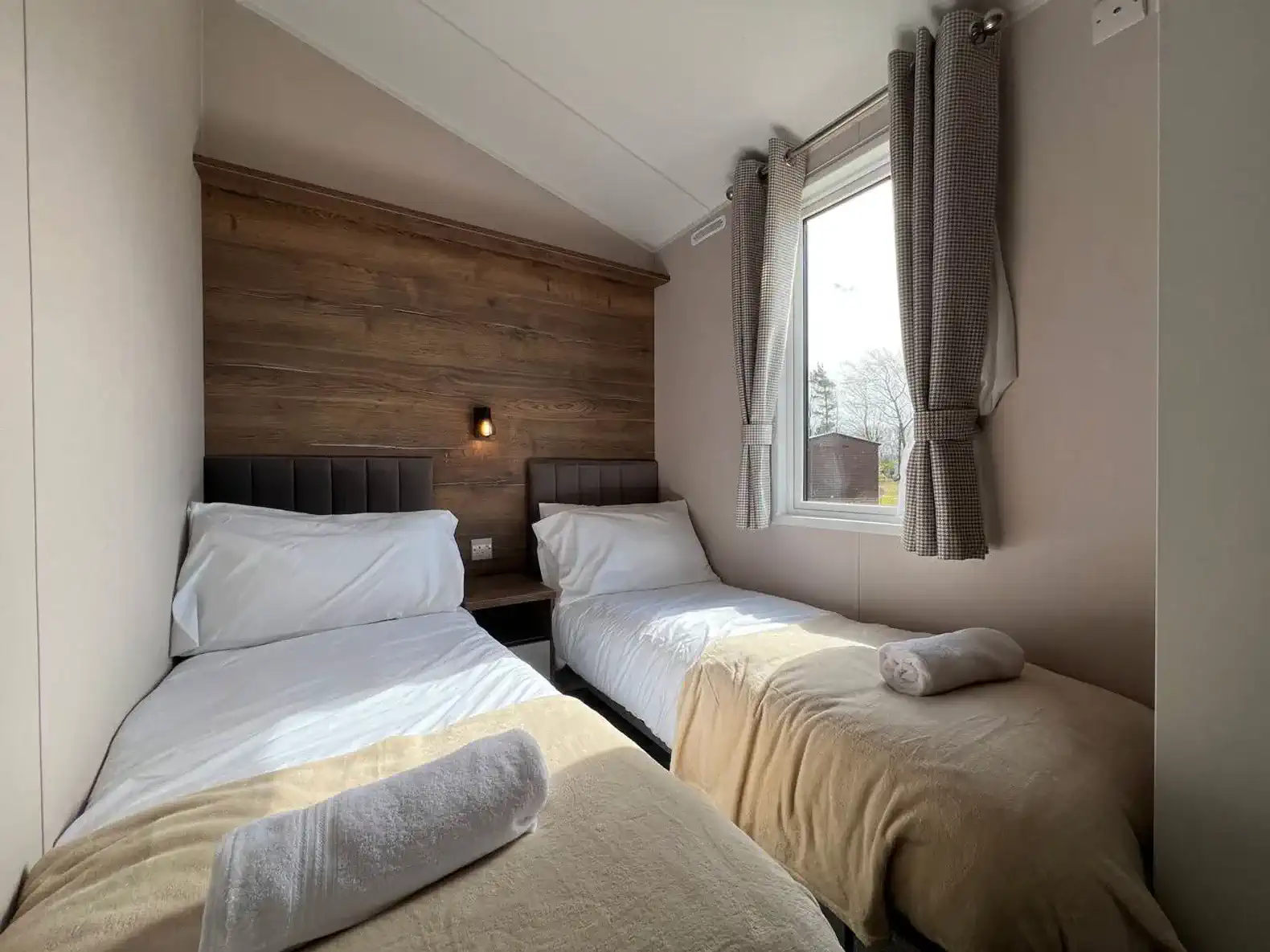 Cozy guest bedroom with two single beds and natural light from the window