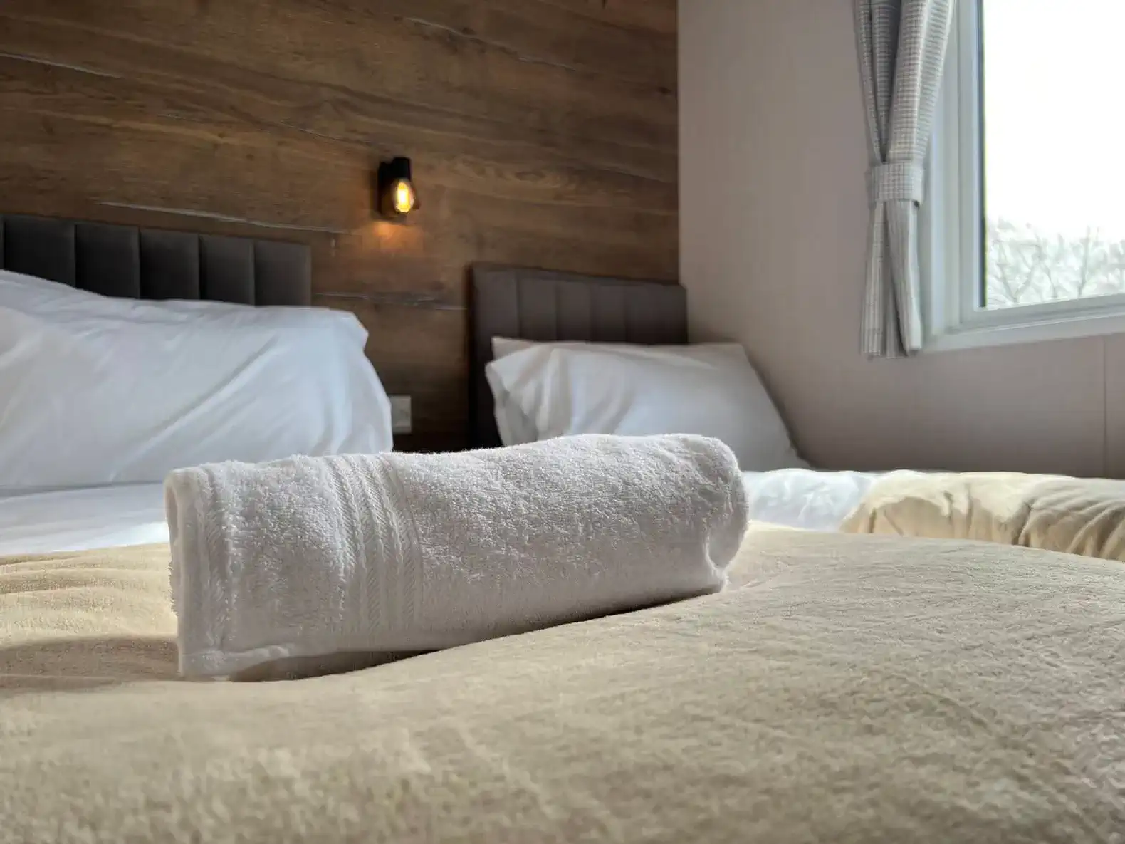 Cozy guest bedroom with two beds and a towel on the bed