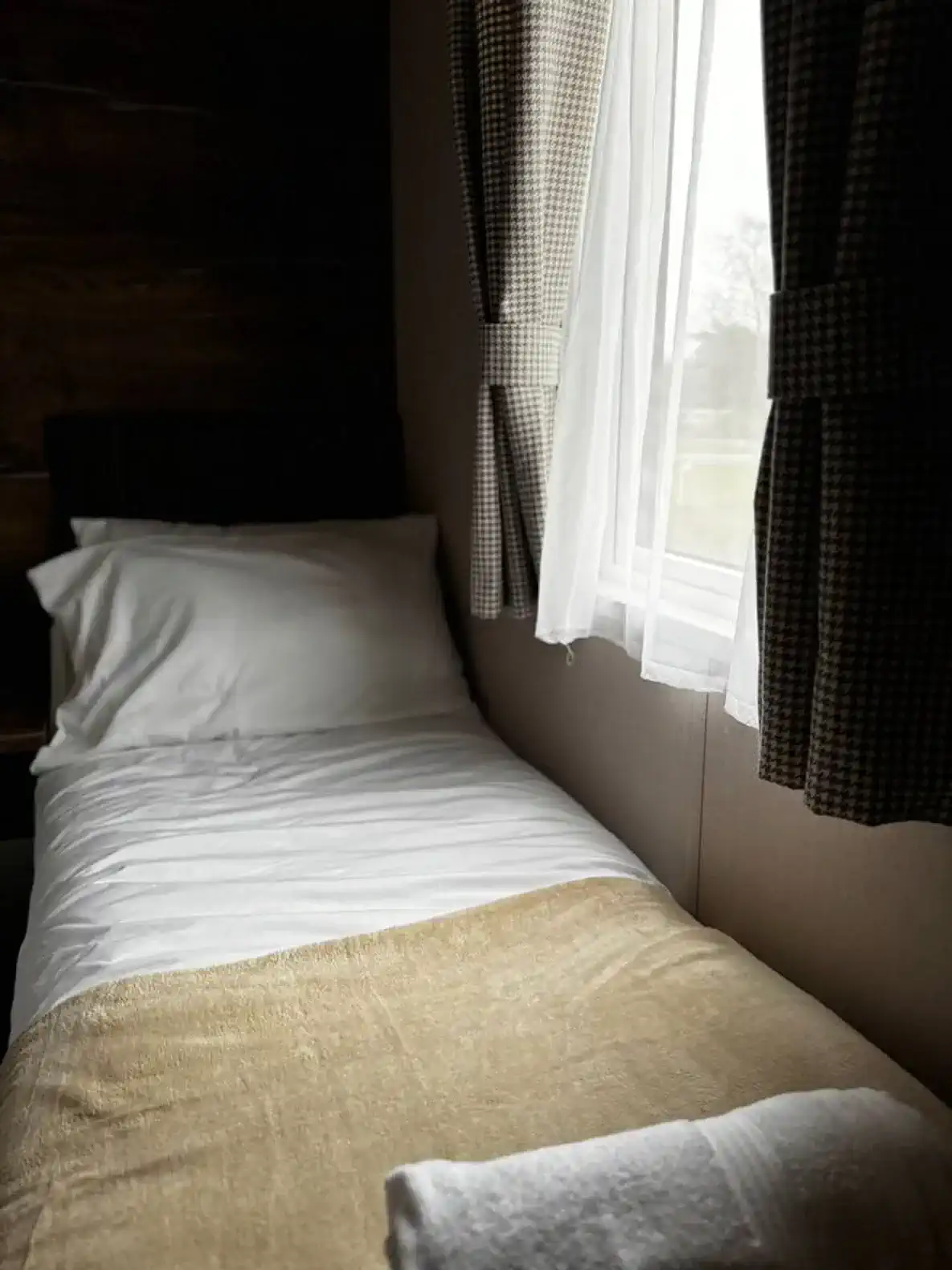 Cozy single bed with soft linens and natural light from the window