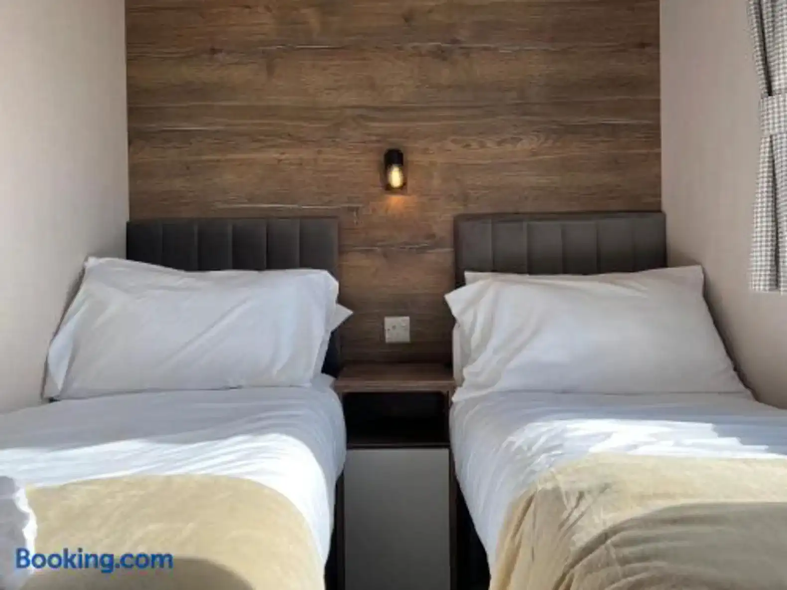 Cozy guest bedroom with two twin beds and wooden accent wall