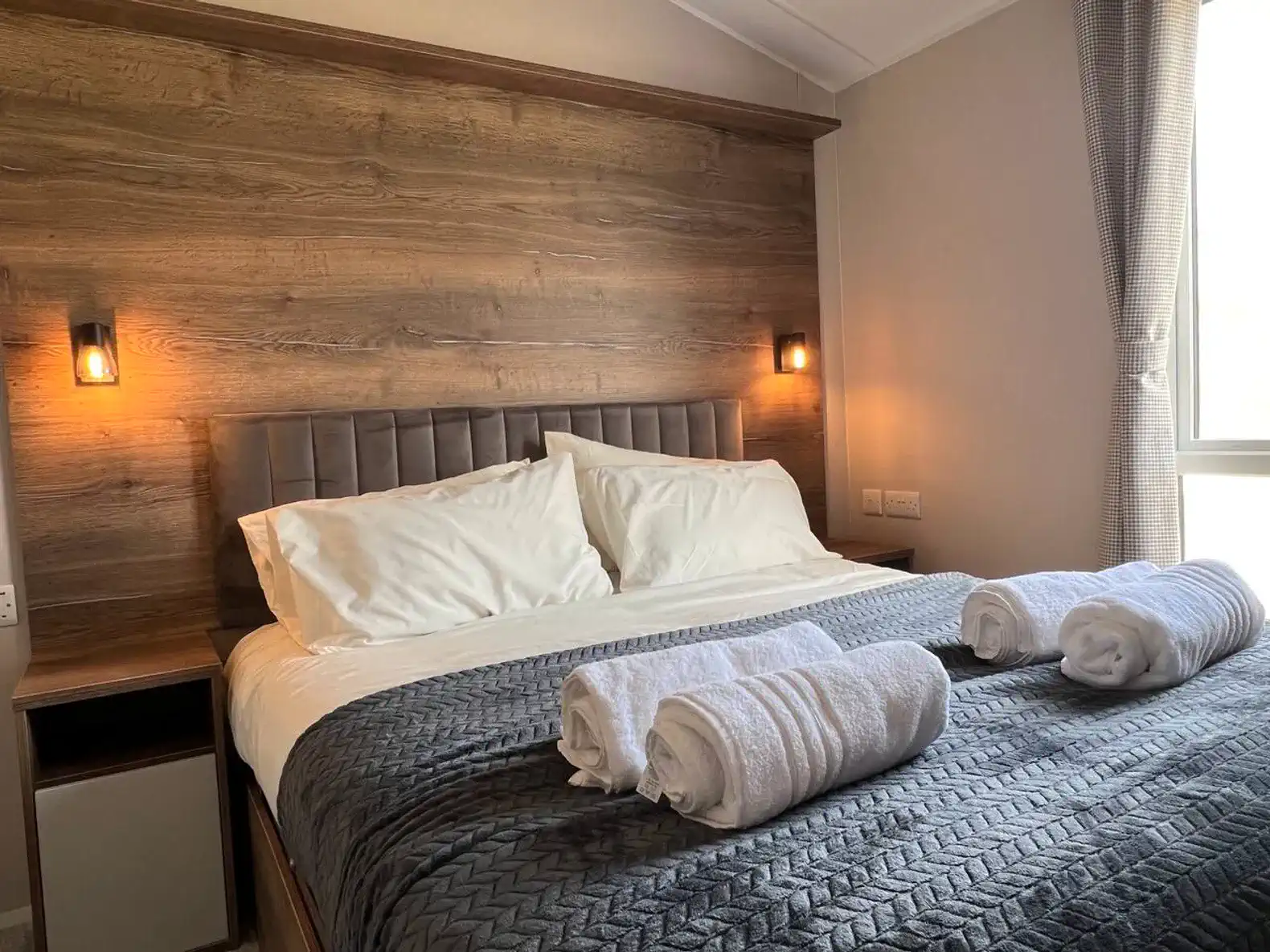 Cozy master bedroom with a large bed, soft linens, and warm lighting