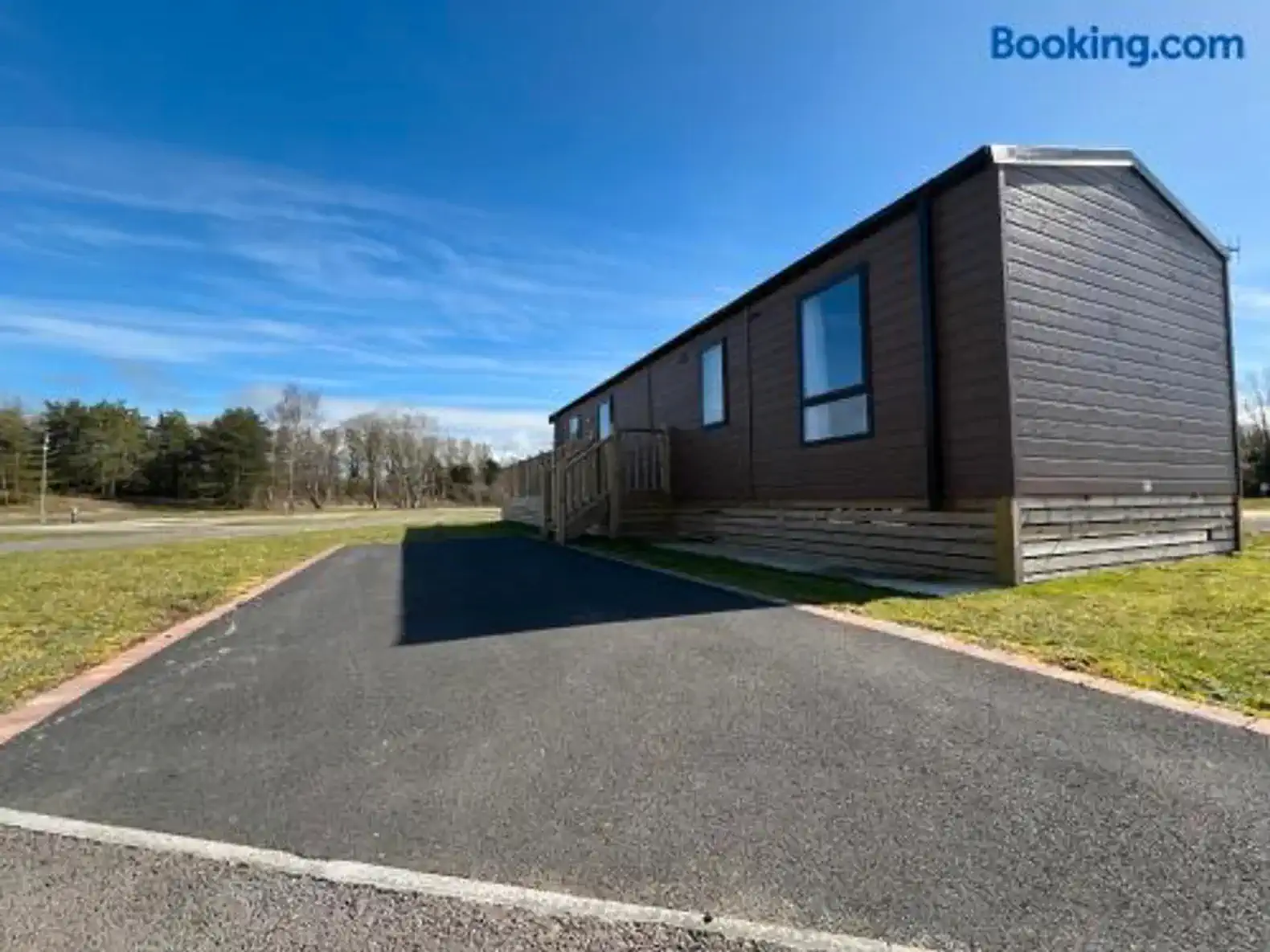 Exterior view of the property with a paved area and grassy surroundings