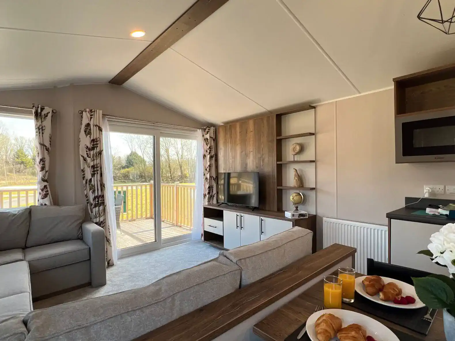 Cozy living room with a view, featuring a sofa, TV, and breakfast spread