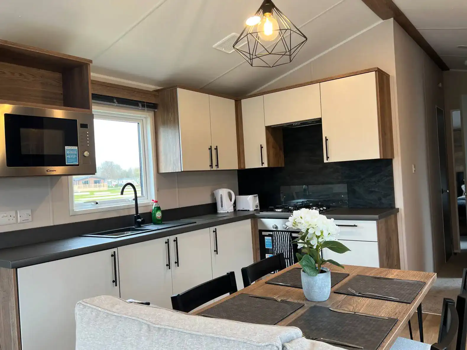 Modern kitchen with sleek cabinets, dining table, and large window
