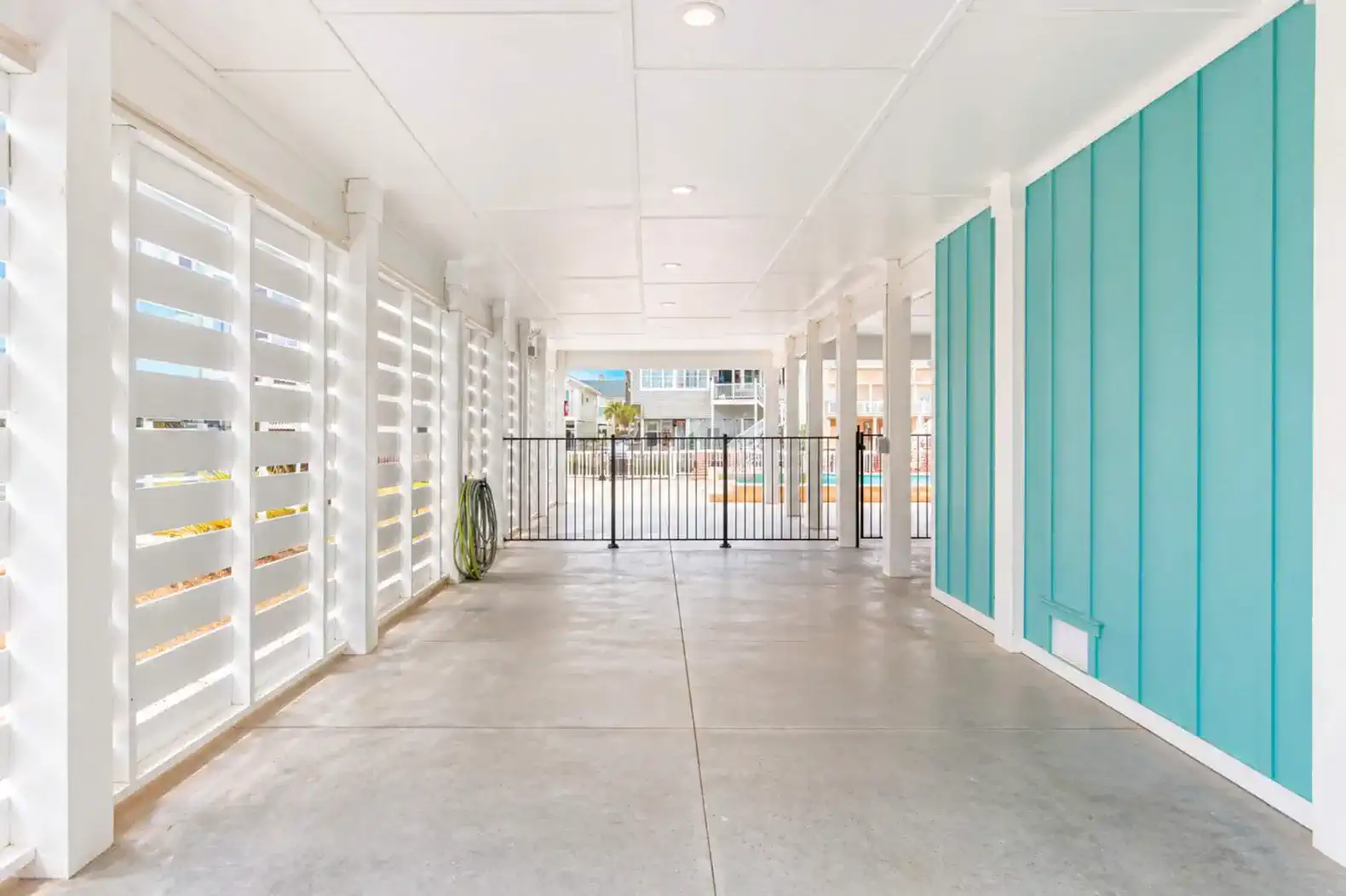 Covered outdoor area with turquoise walls and gated access to the pool