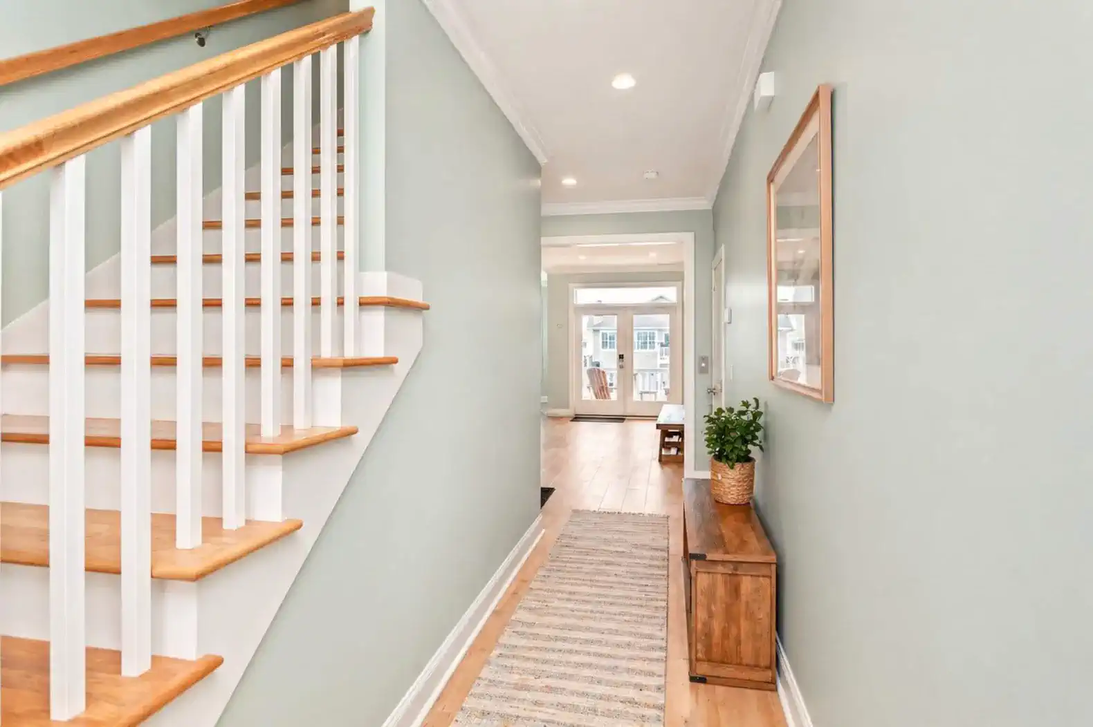 Welcoming hallway with stairs leading to upper floor and access to living area