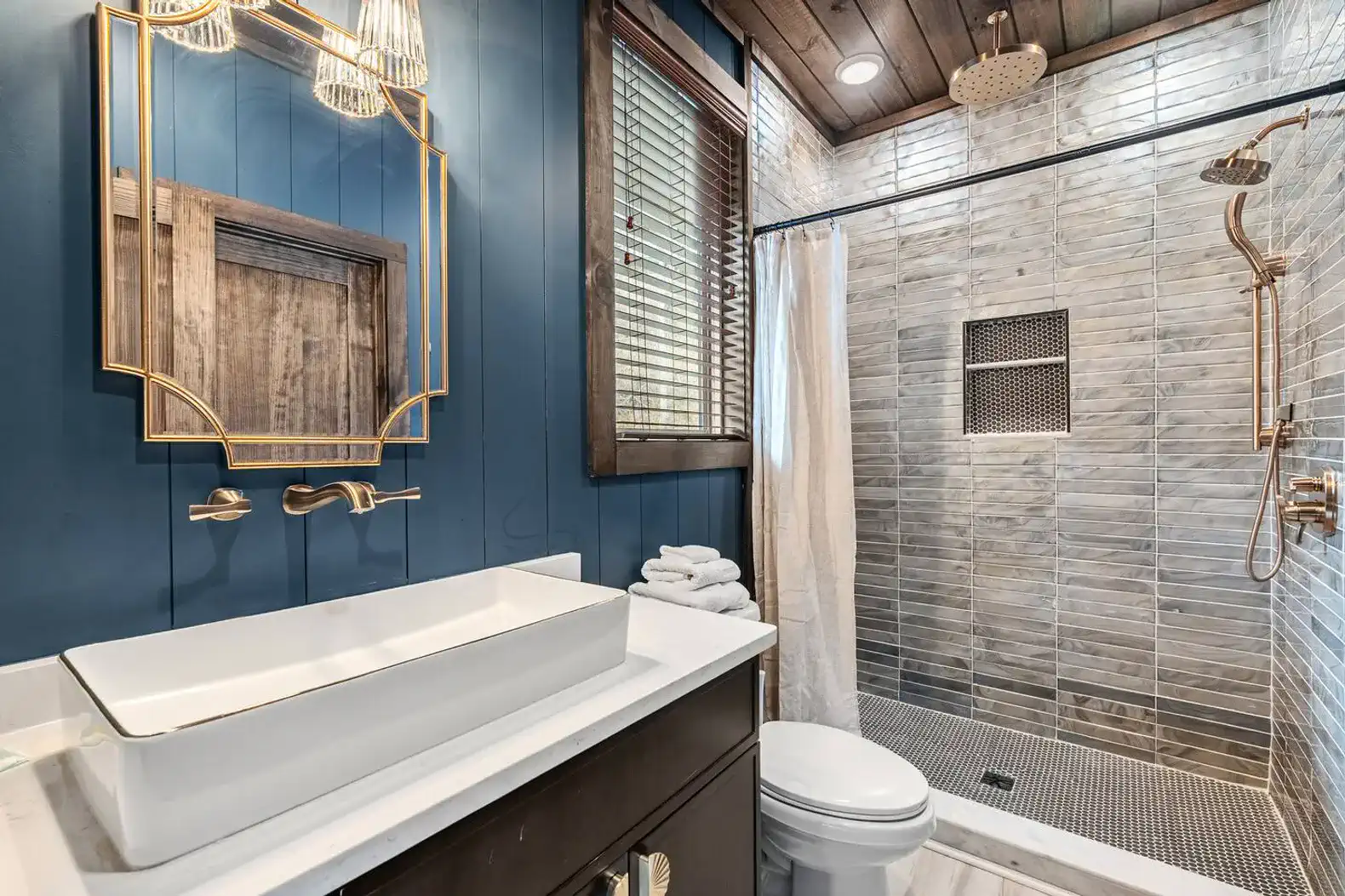 An ensuite bathroom right off the master with dual shower heads,  shampoo, conditioner, body soap, and towels. 