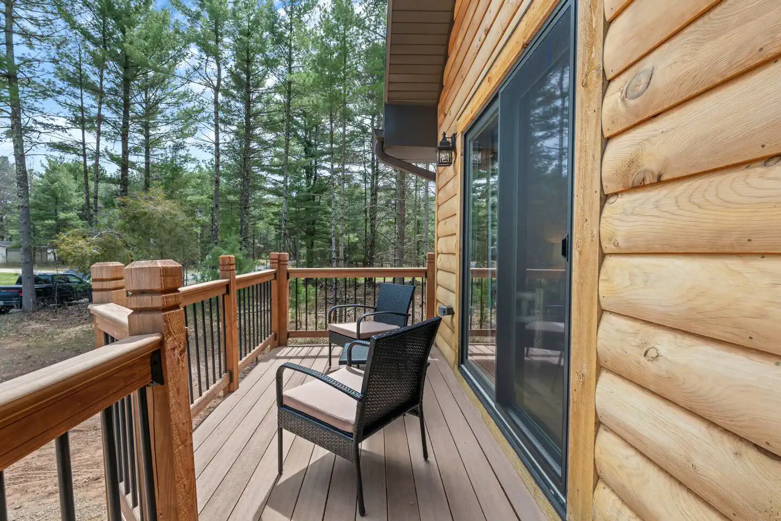 Cozy deck with seating surrounded by tall trees