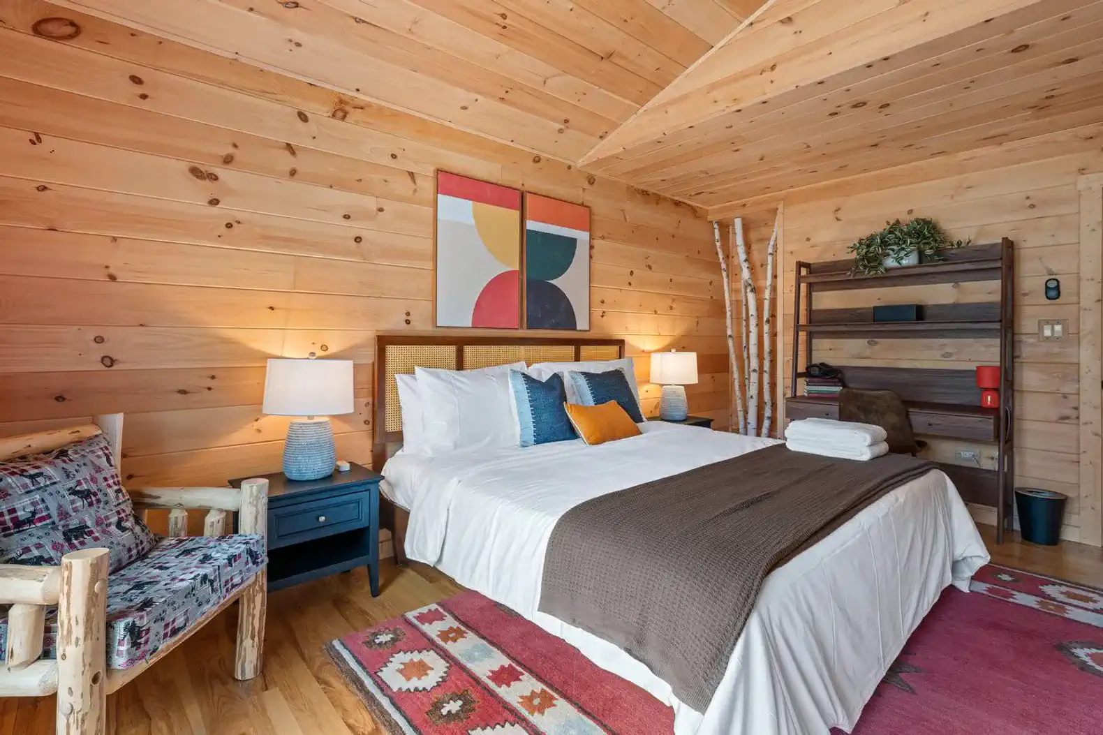 Cozy master bedroom with wooden walls, a large bed, and rustic decor