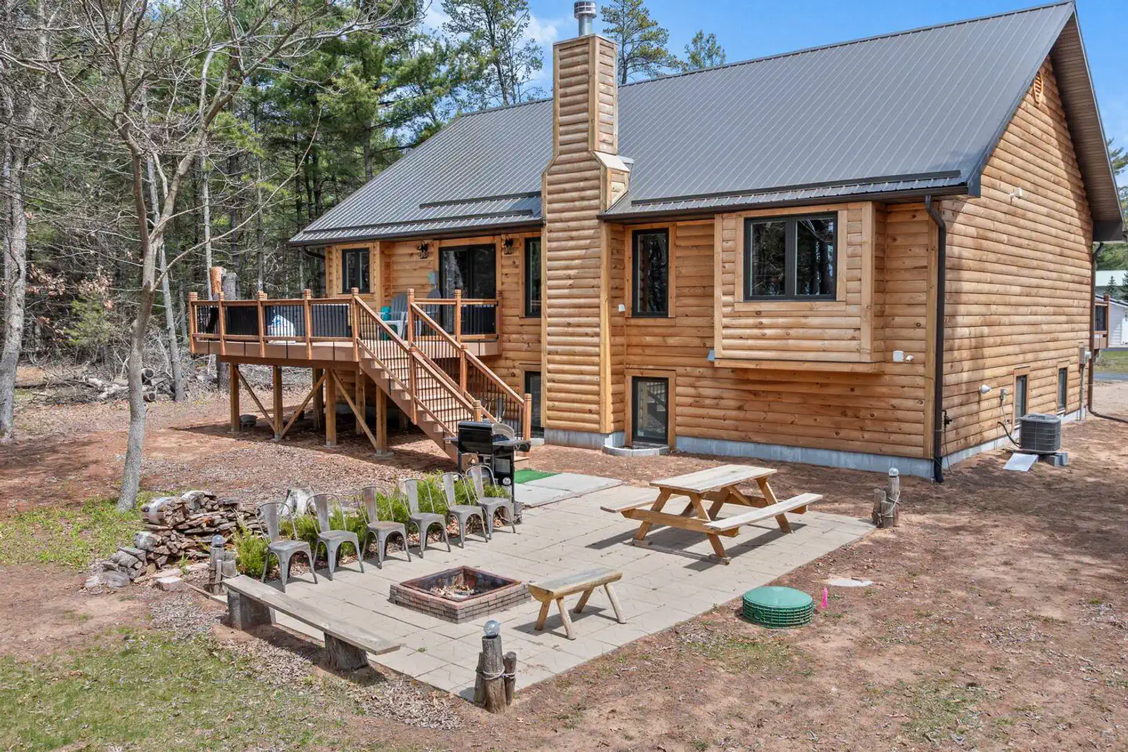 Outdoor seating area with fire pit and picnic table surrounded by trees