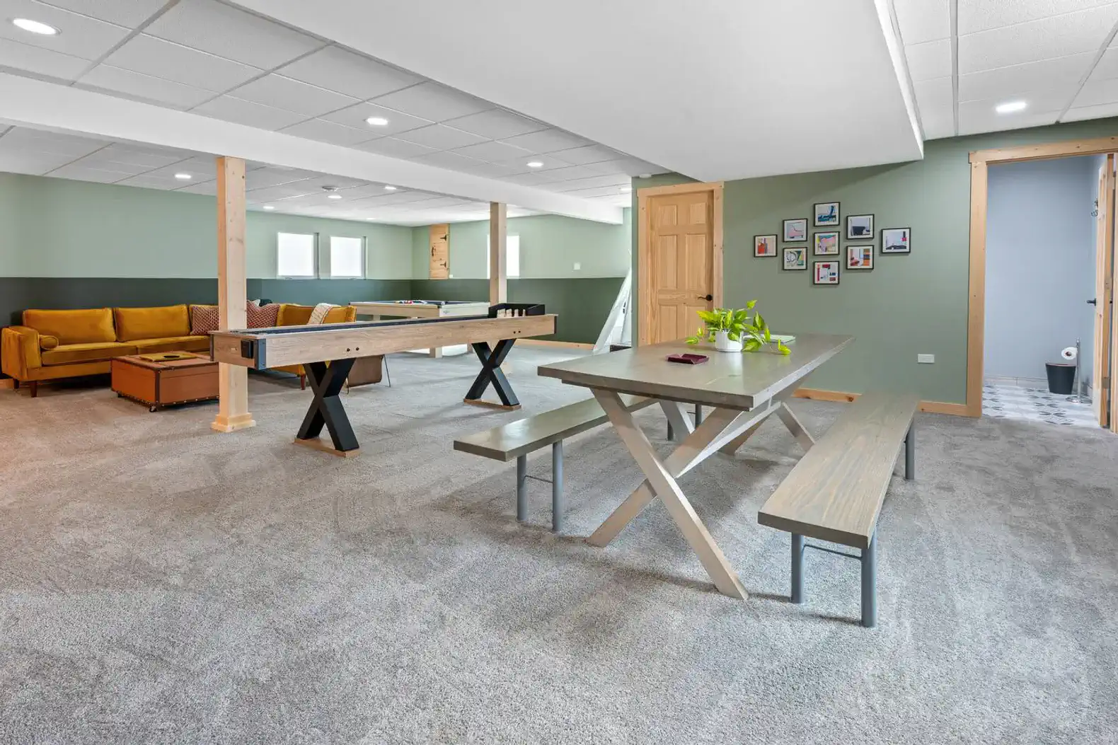 Spacious game room with a pool table, seating area, and dining table