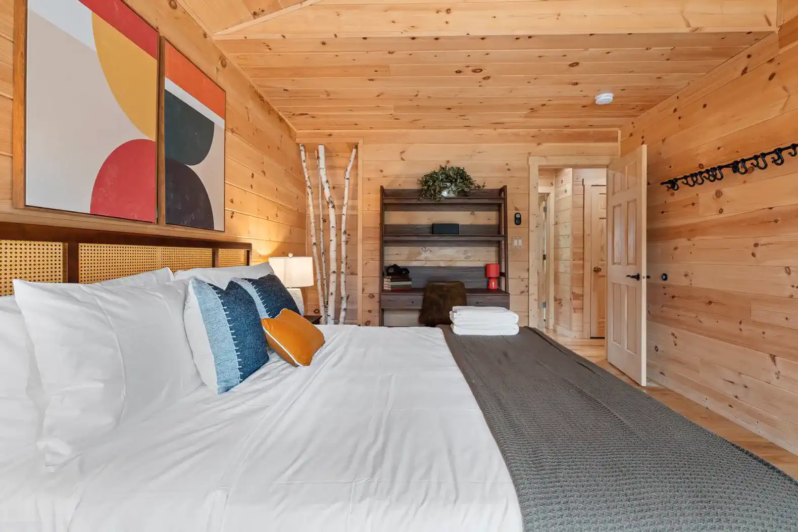 Cozy master bedroom with wooden walls, large bed, and decorative artwork