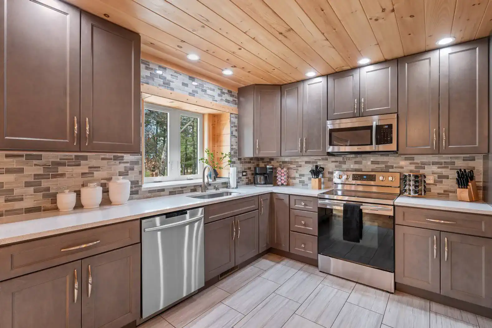 Modern kitchen with stainless steel appliances and wooden ceiling