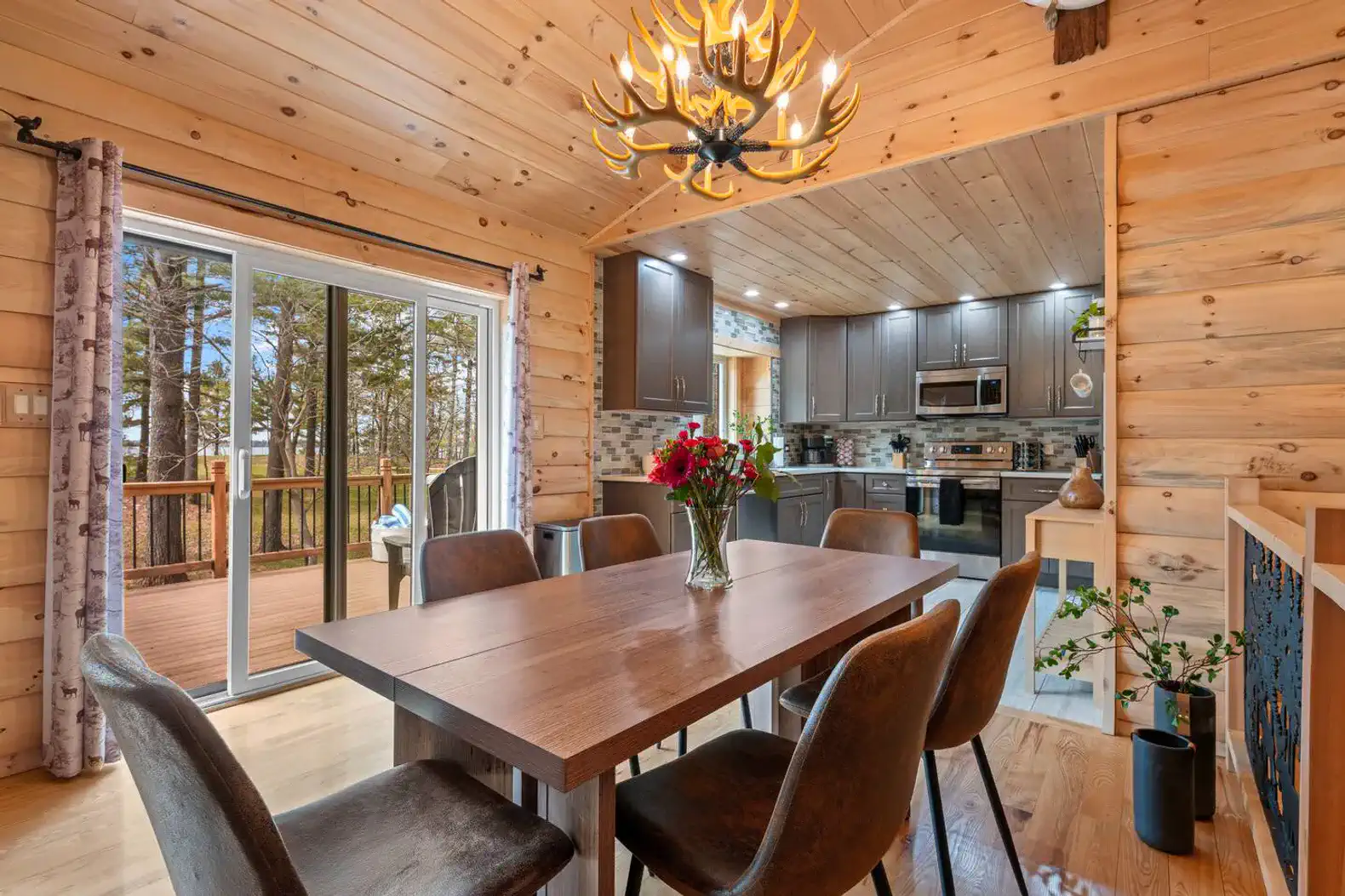 Spacious dining area with wooden table and modern kitchen in the background