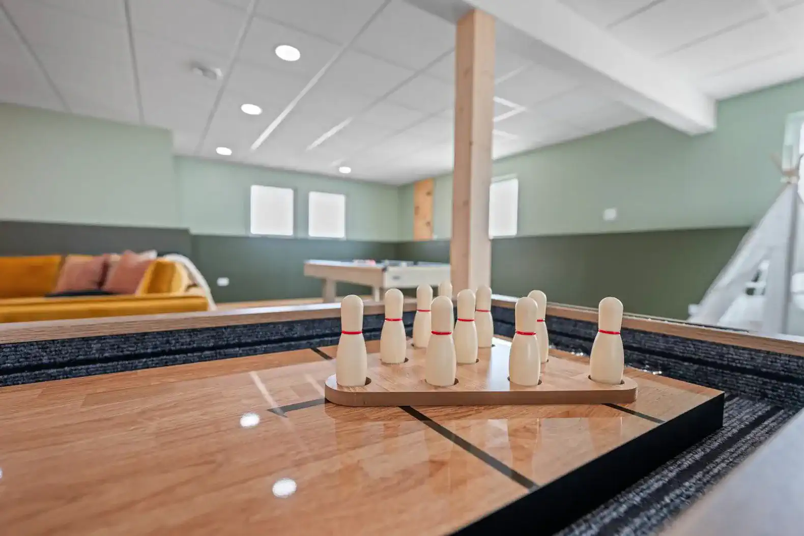 Indoor game area featuring a bowling setup and a cozy seating area