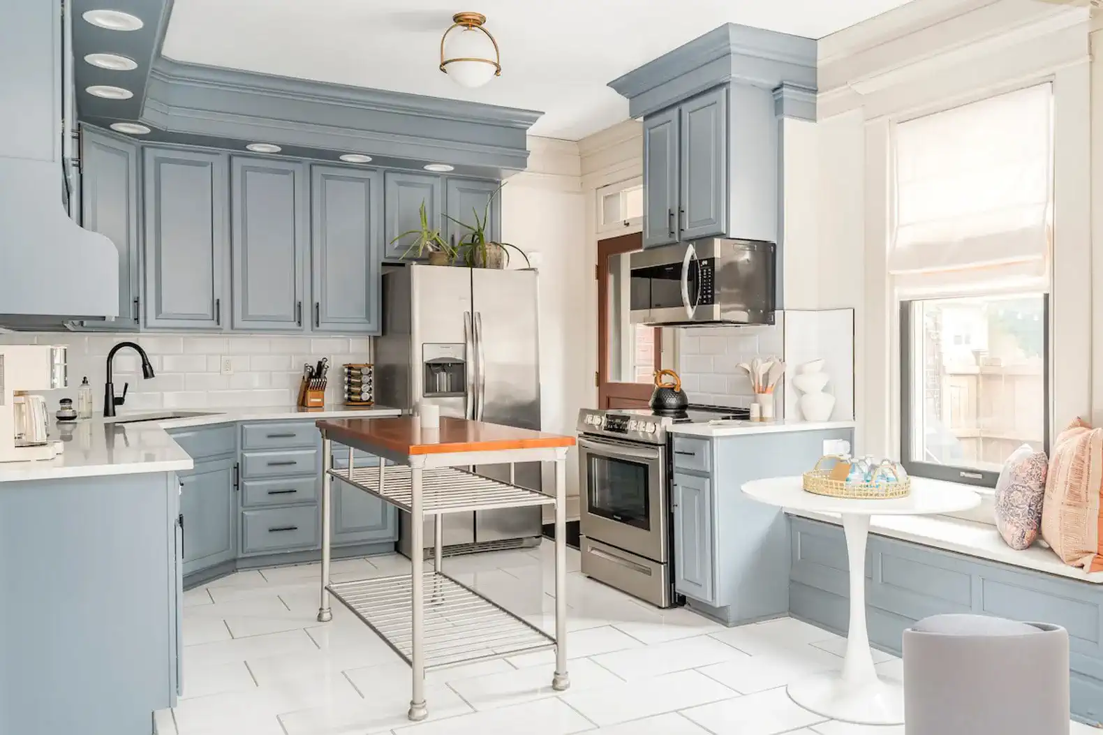 Modern kitchen with blue cabinets, stainless steel appliances, and a central island