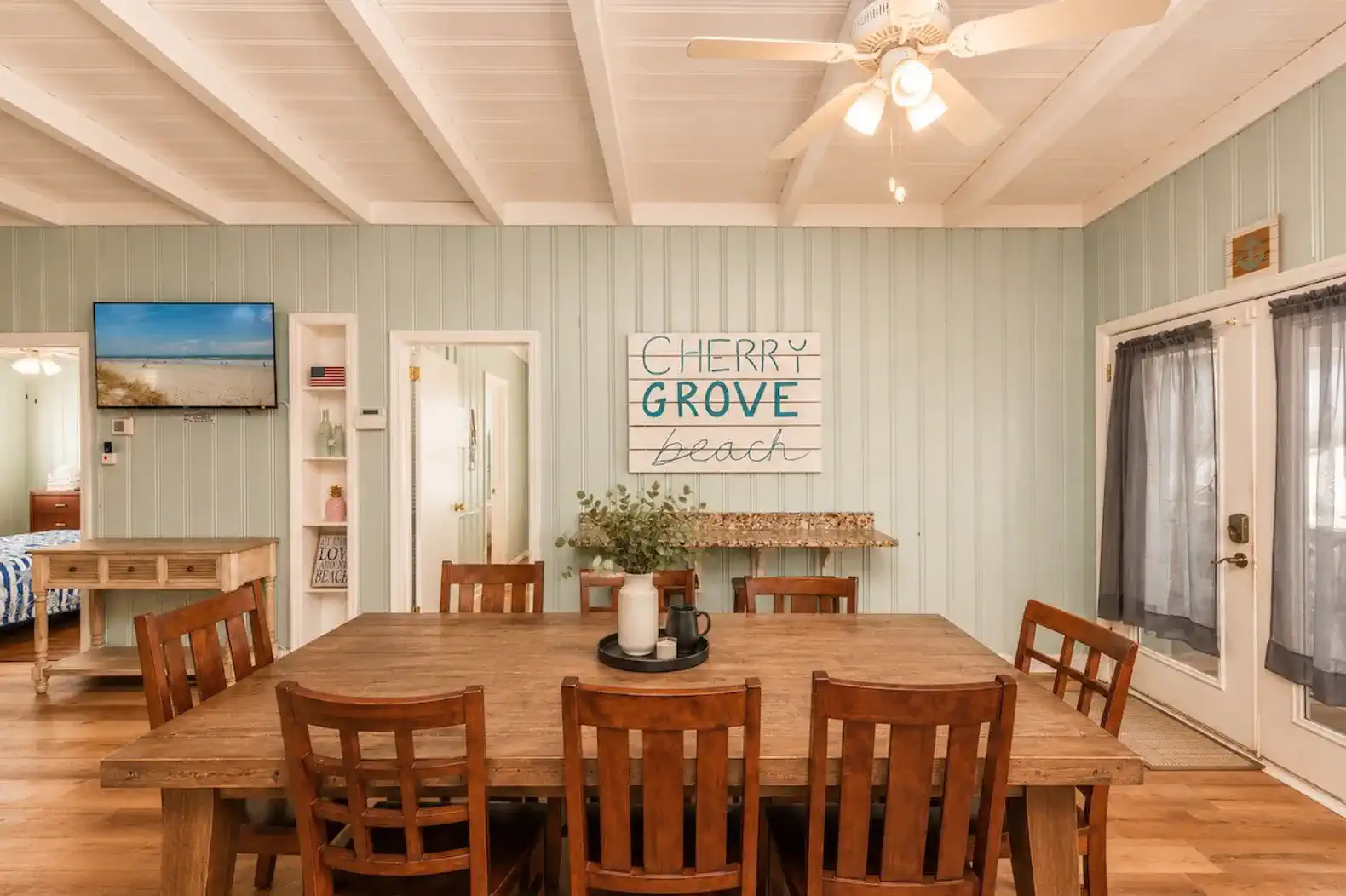 Spacious dining area with a large wooden table and beach-themed decor