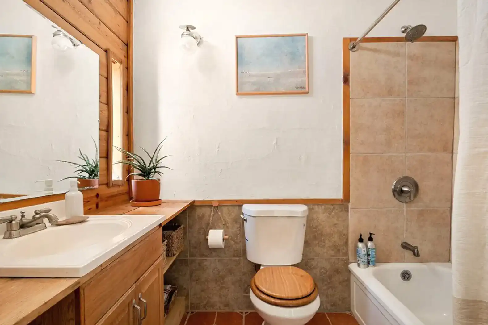 Cozy bathroom featuring a bathtub, wooden accents, and natural light