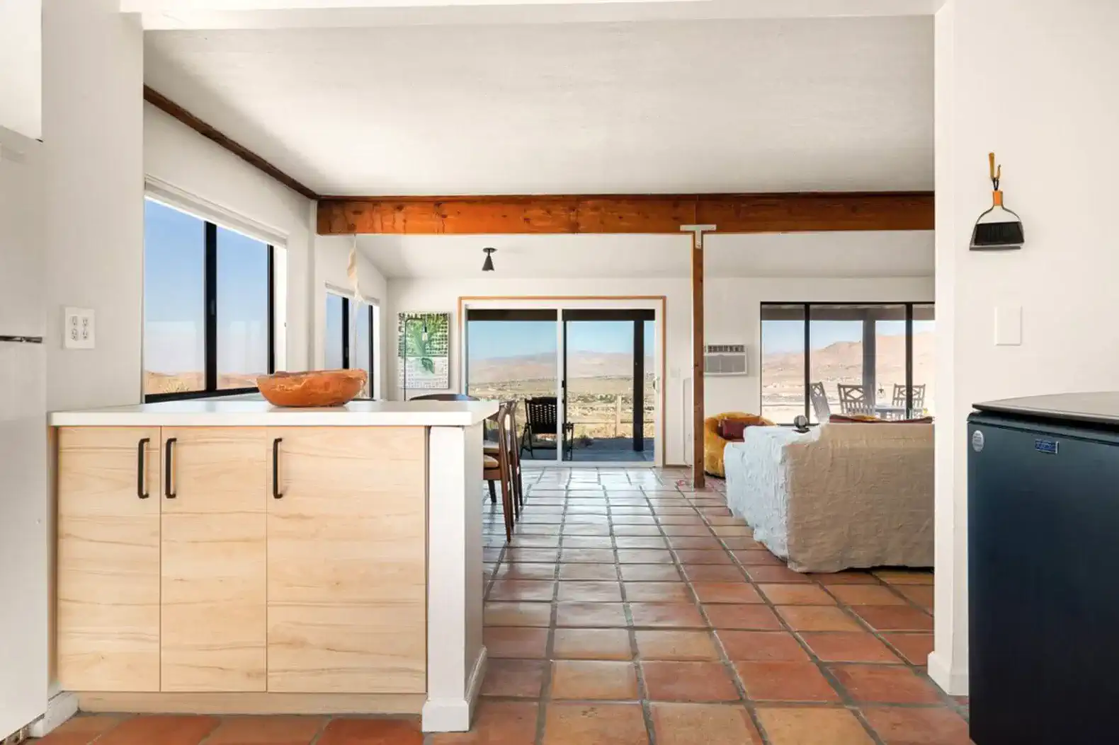Open living space with kitchen and dining area featuring large windows and desert views