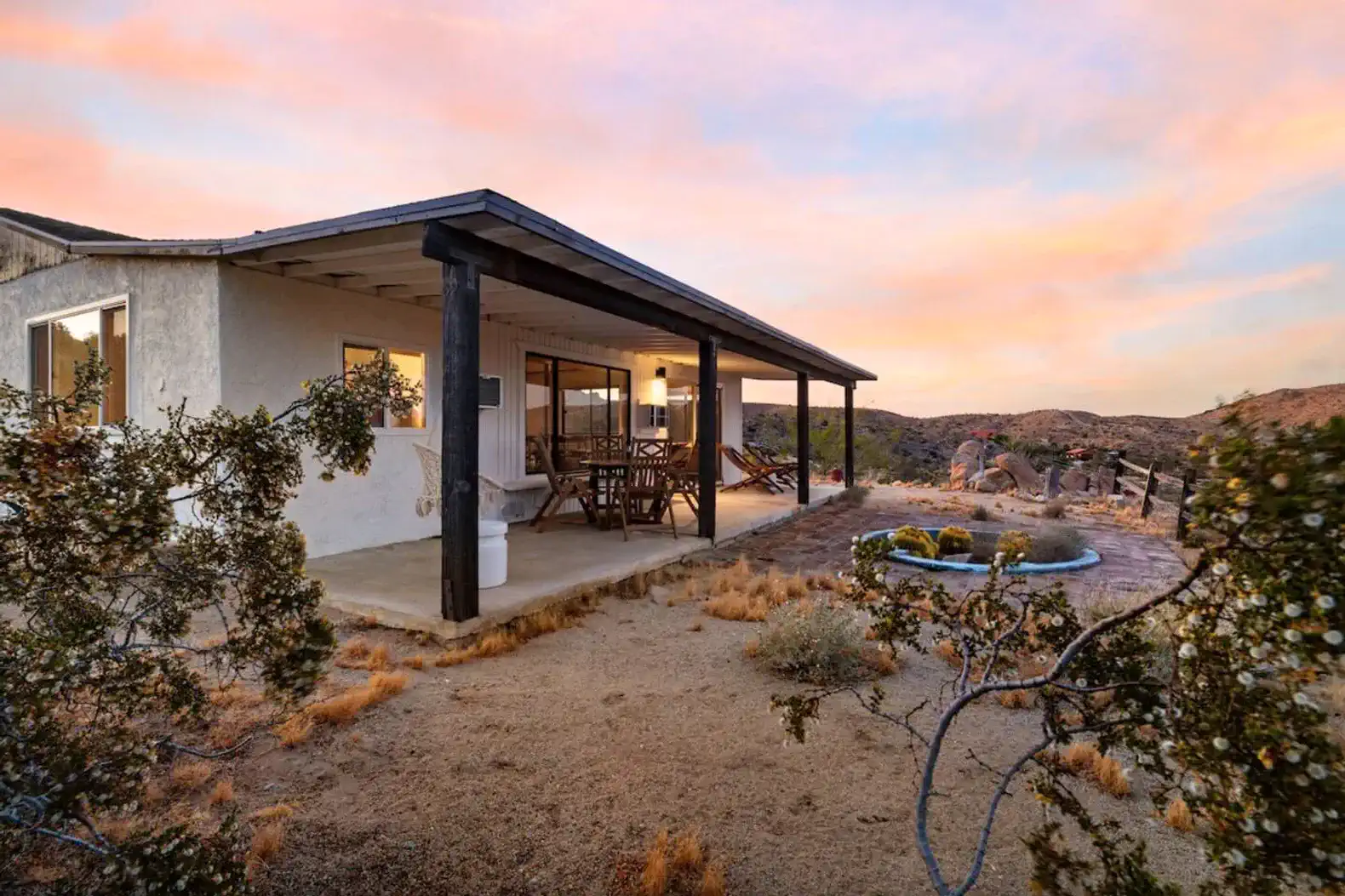 Outdoor patio area with seating and desert landscape at sunset