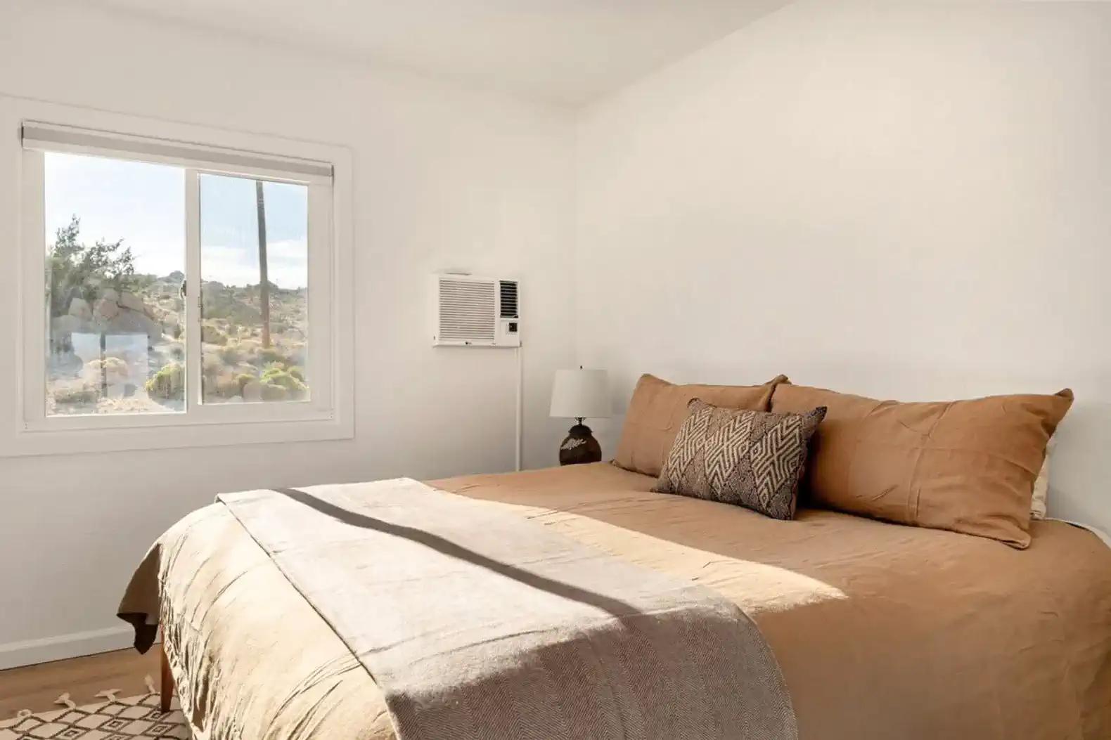 Cozy master bedroom with a large bed and window showcasing desert views