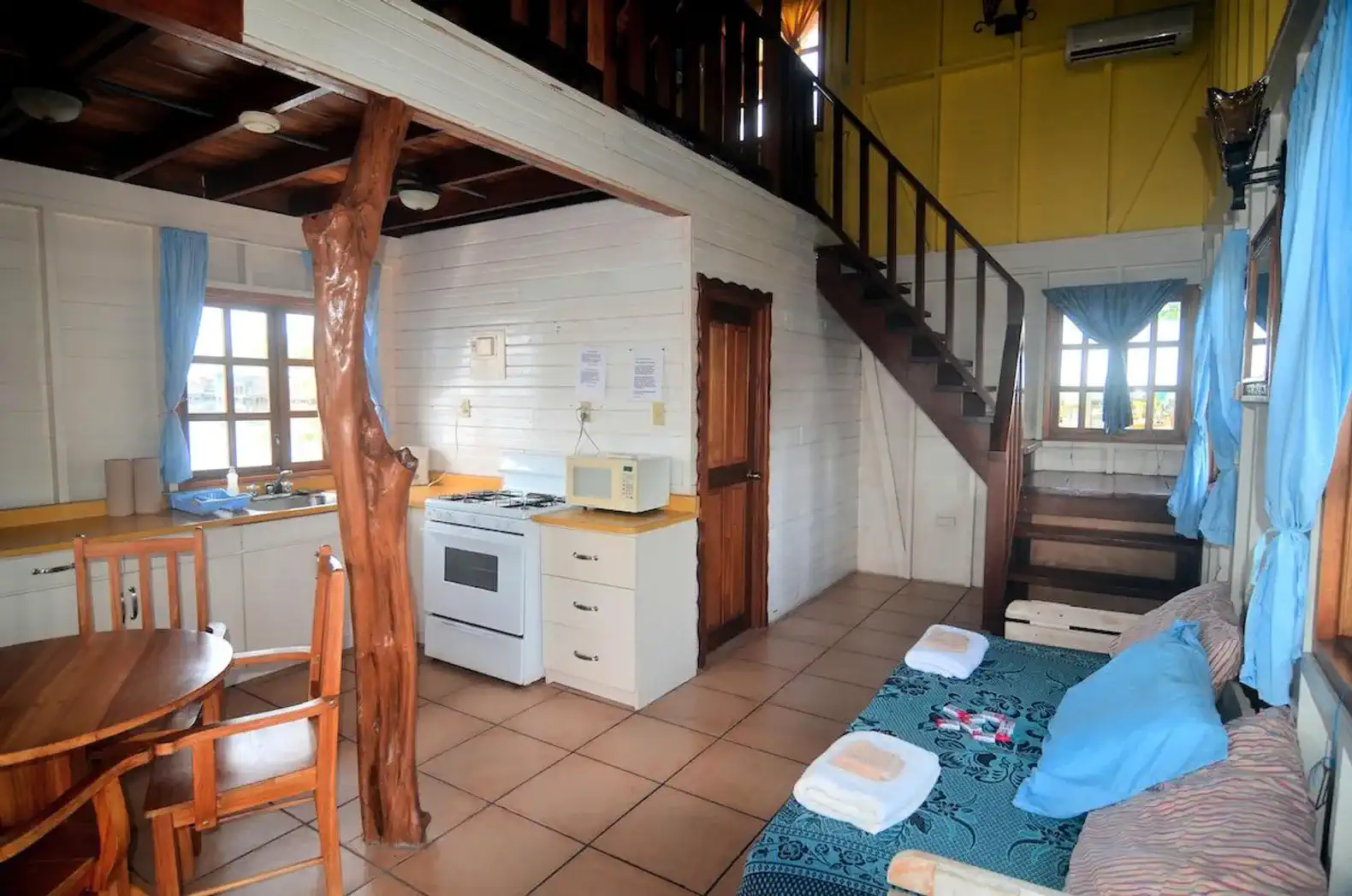 Cozy living area with kitchen, dining table, and staircase