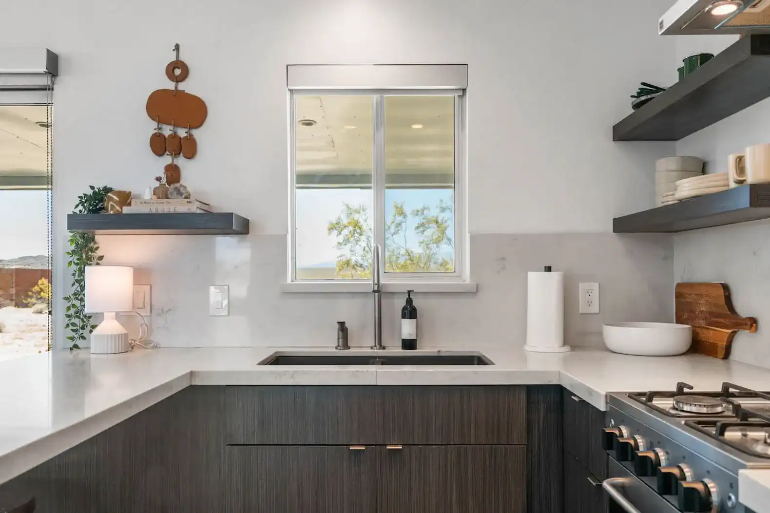 Modern kitchen with sleek countertops and window view of desert landscape