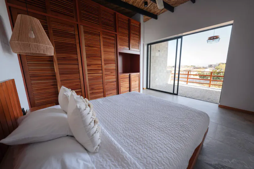 Habitación luminosa con cama grande y acceso a balcón