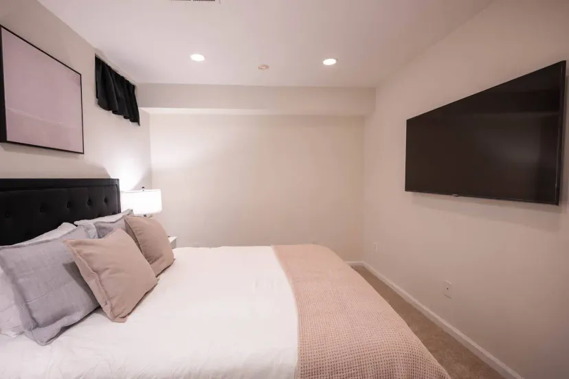 Cozy bedroom with a large TV and soft bedding