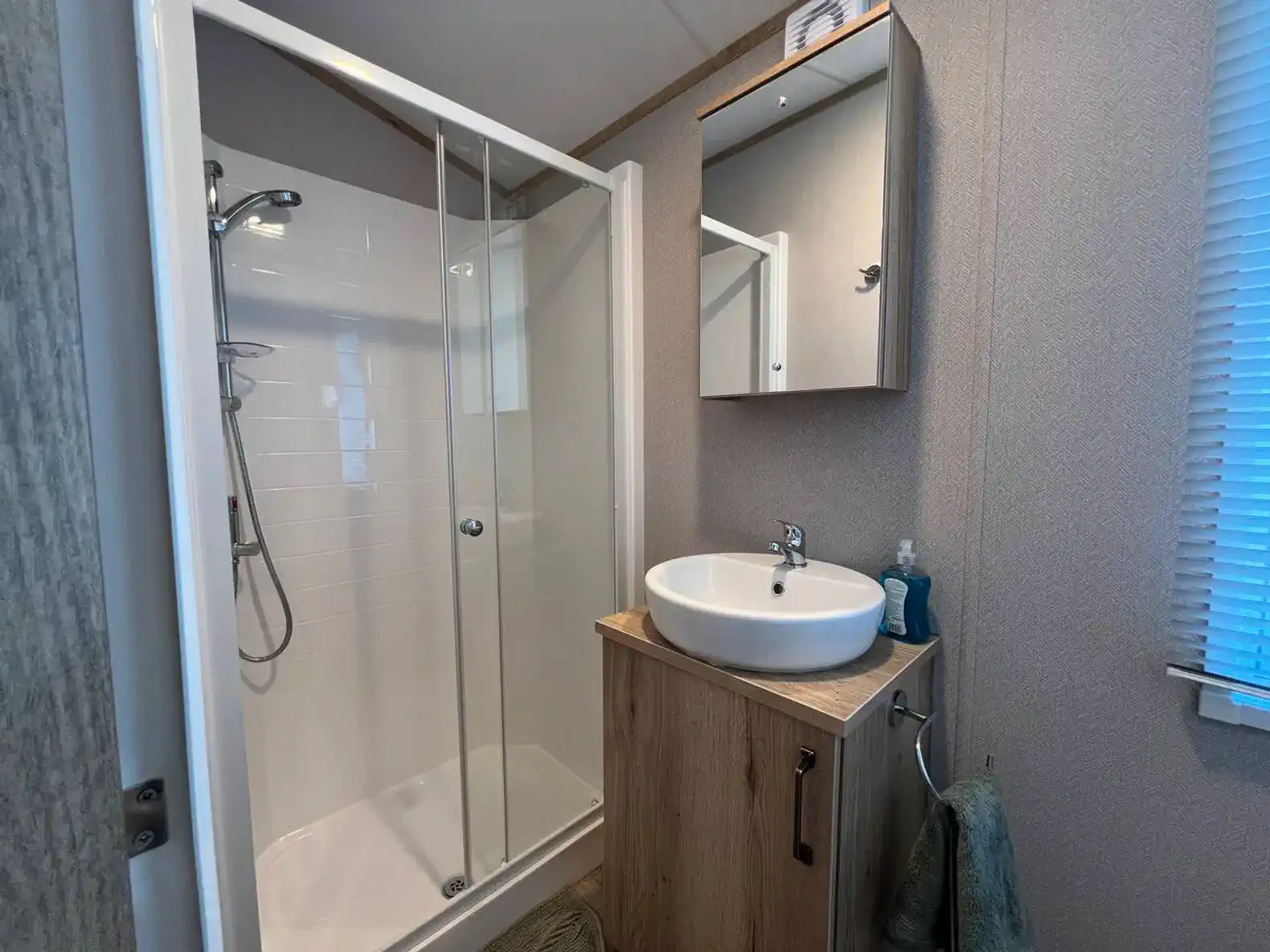 Modern bathroom featuring a shower, sink, and mirror