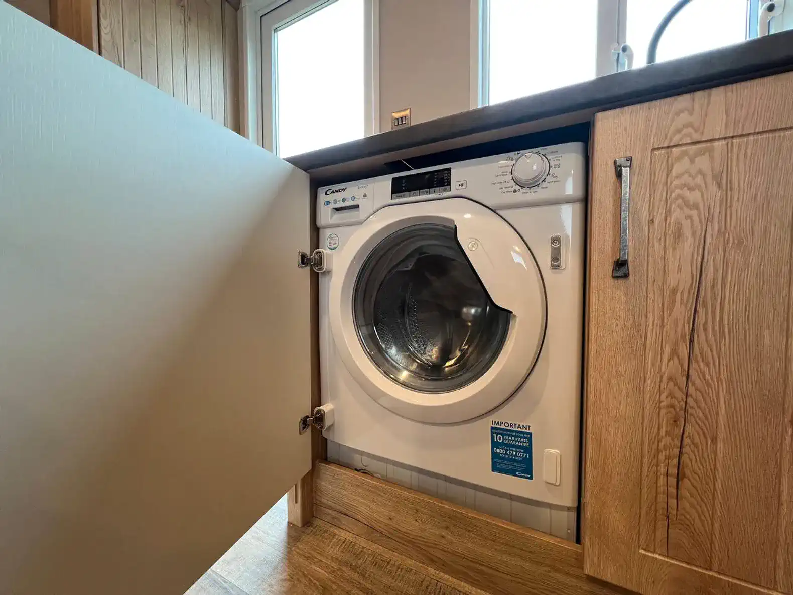 Compact washing machine installed in kitchen cabinetry