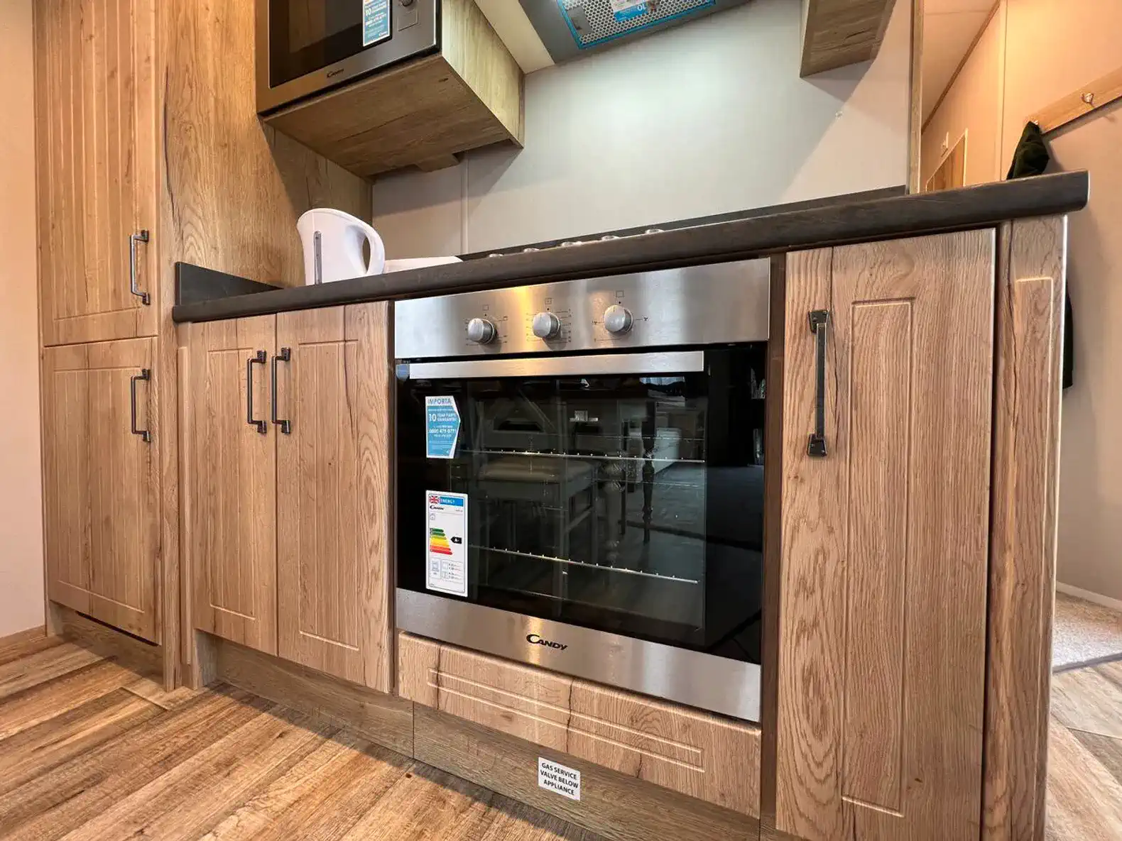 Modern kitchen featuring a stainless steel oven and wooden cabinetry