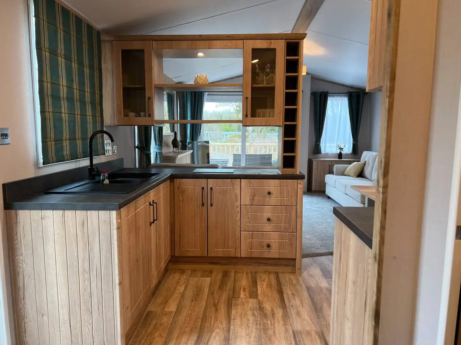 Modern kitchen with wooden cabinets and sink overlooking the living area