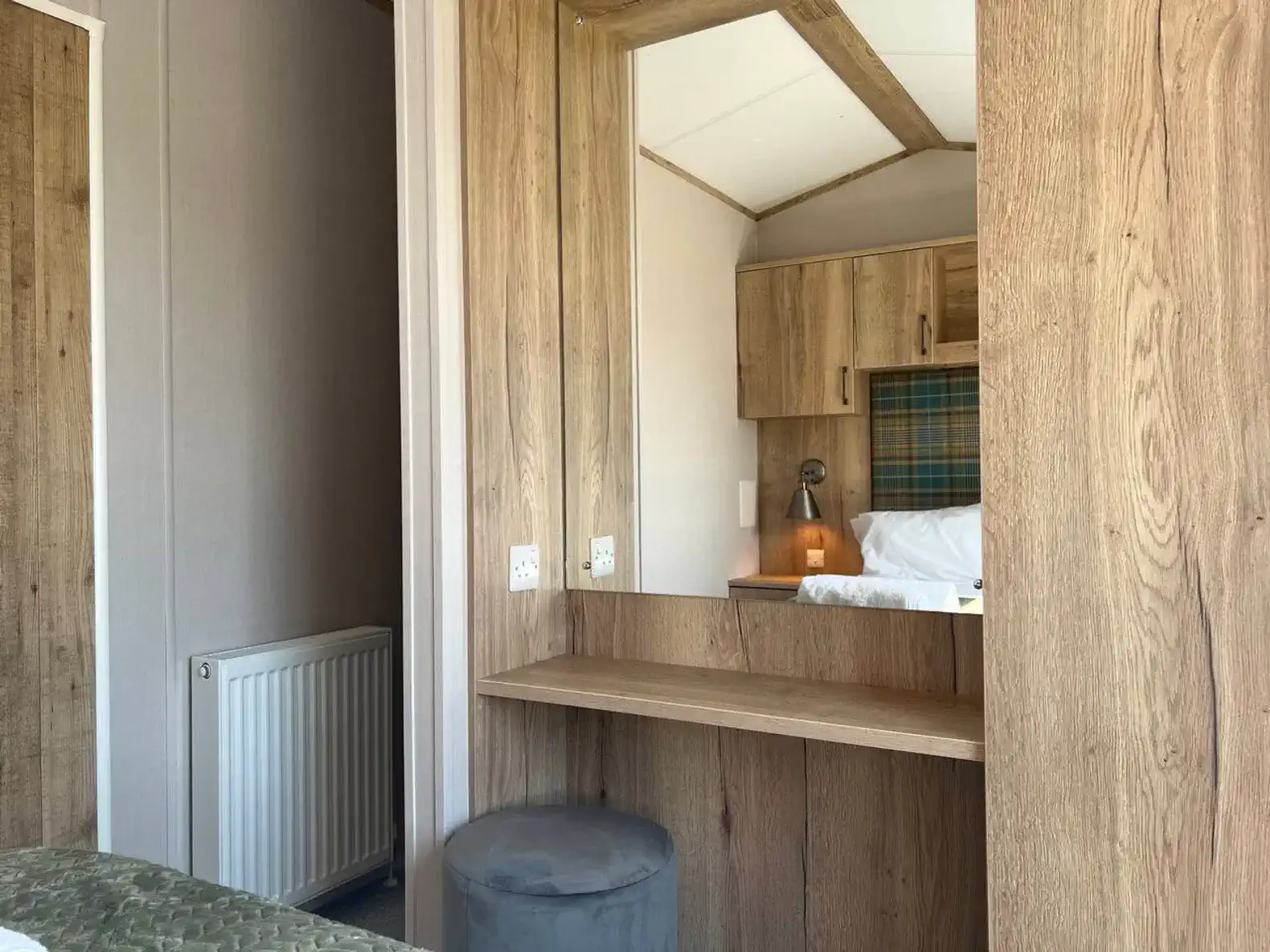 Cozy bedroom corner with a wooden vanity and mirror