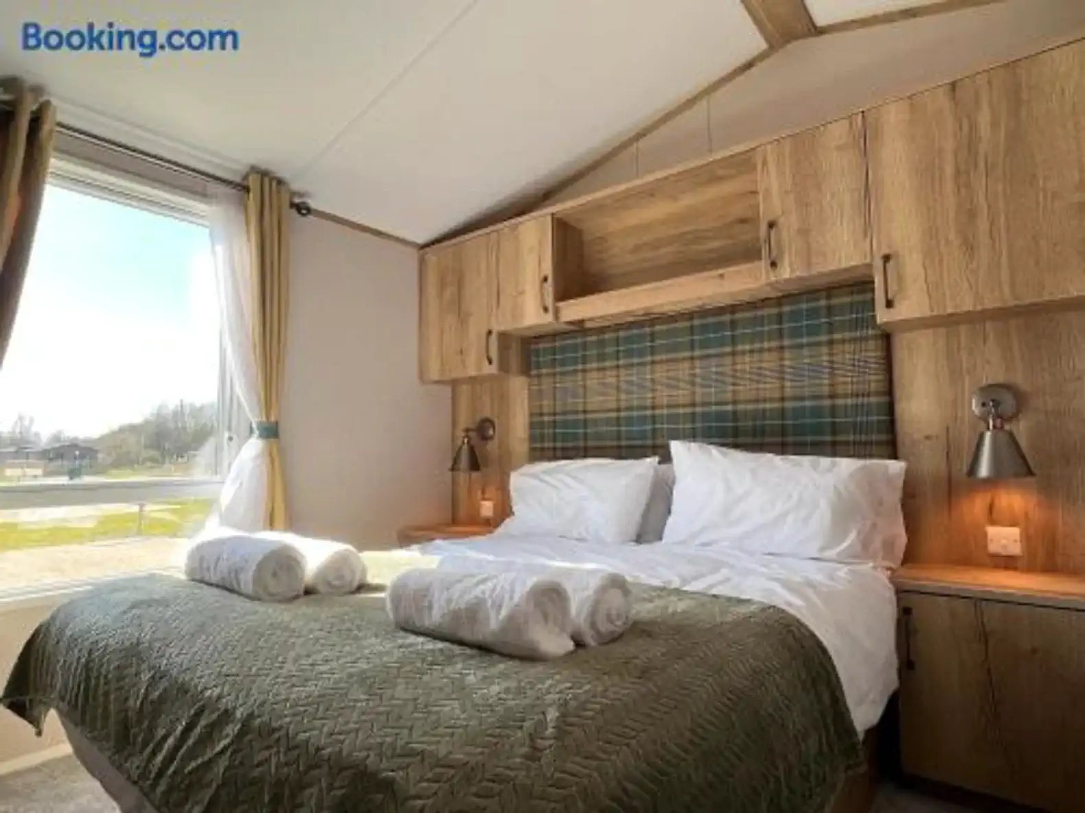 Cozy master bedroom with large windows and wooden accents