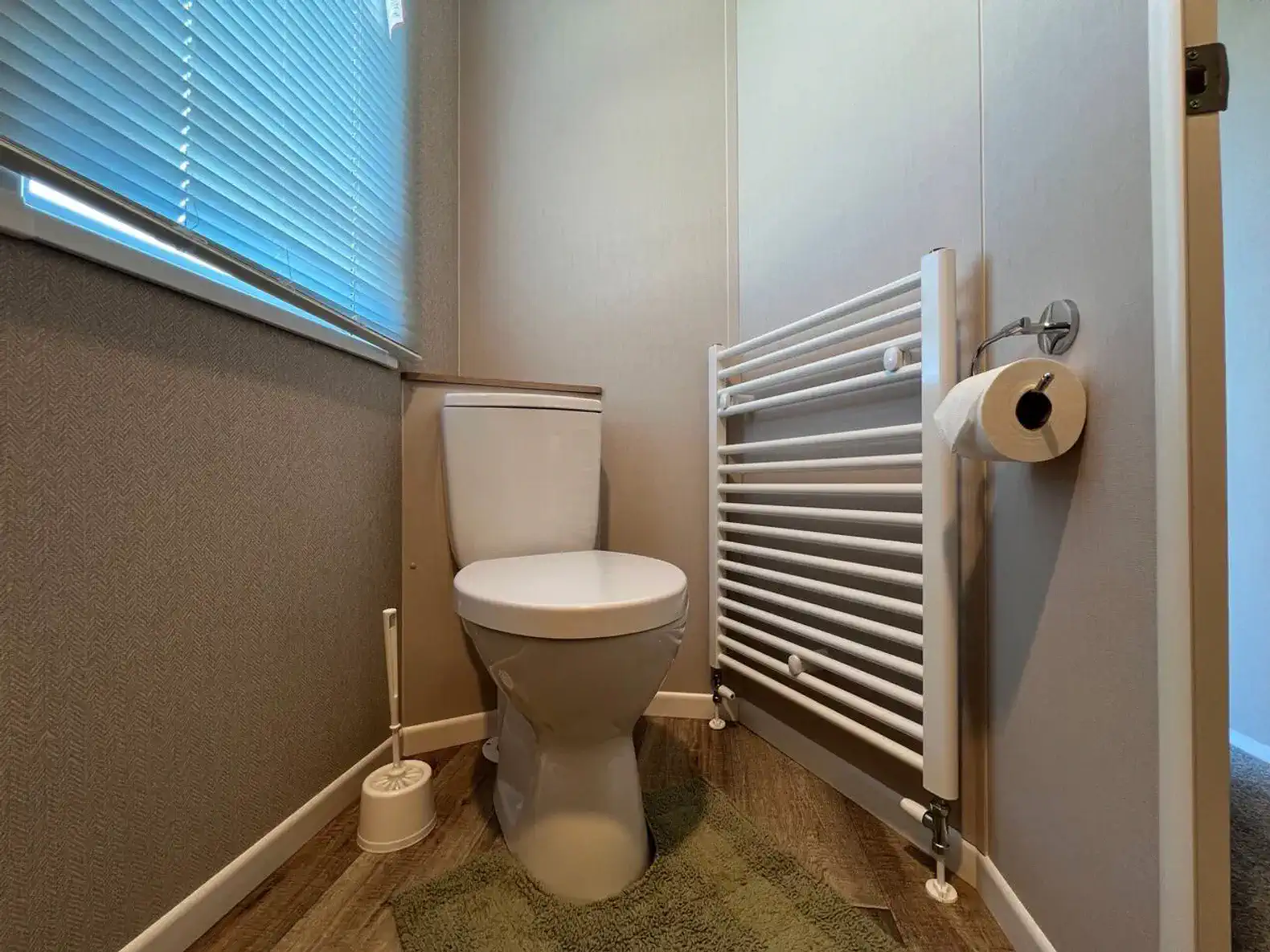 Compact bathroom featuring a modern toilet and towel radiator