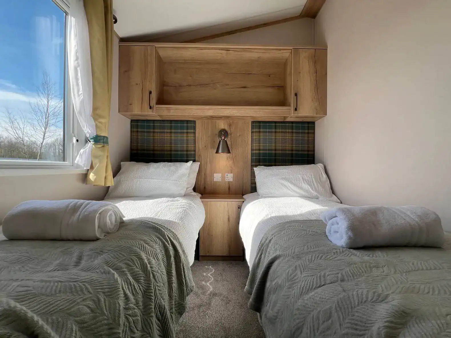 Cozy twin bedroom with wooden accents and plaid headboard