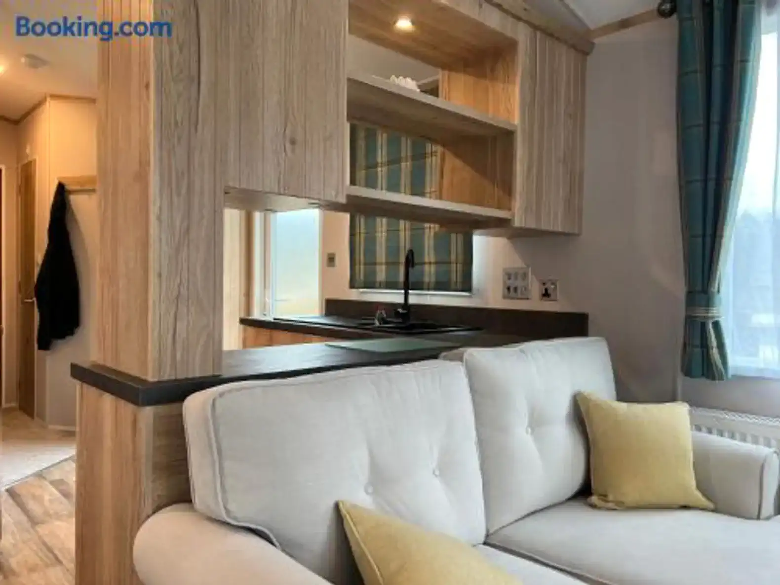 Cozy living area with a sofa and kitchen bar in the background