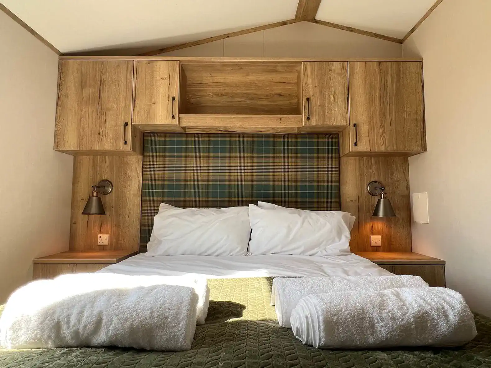 Cozy master bedroom with wooden cabinetry and plaid headboard