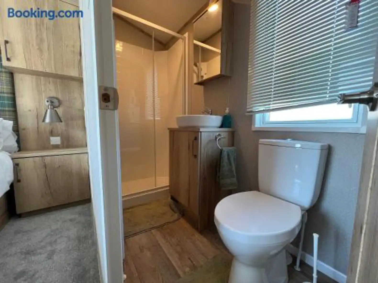 Compact bathroom featuring a shower, sink, and toilet with modern fixtures
