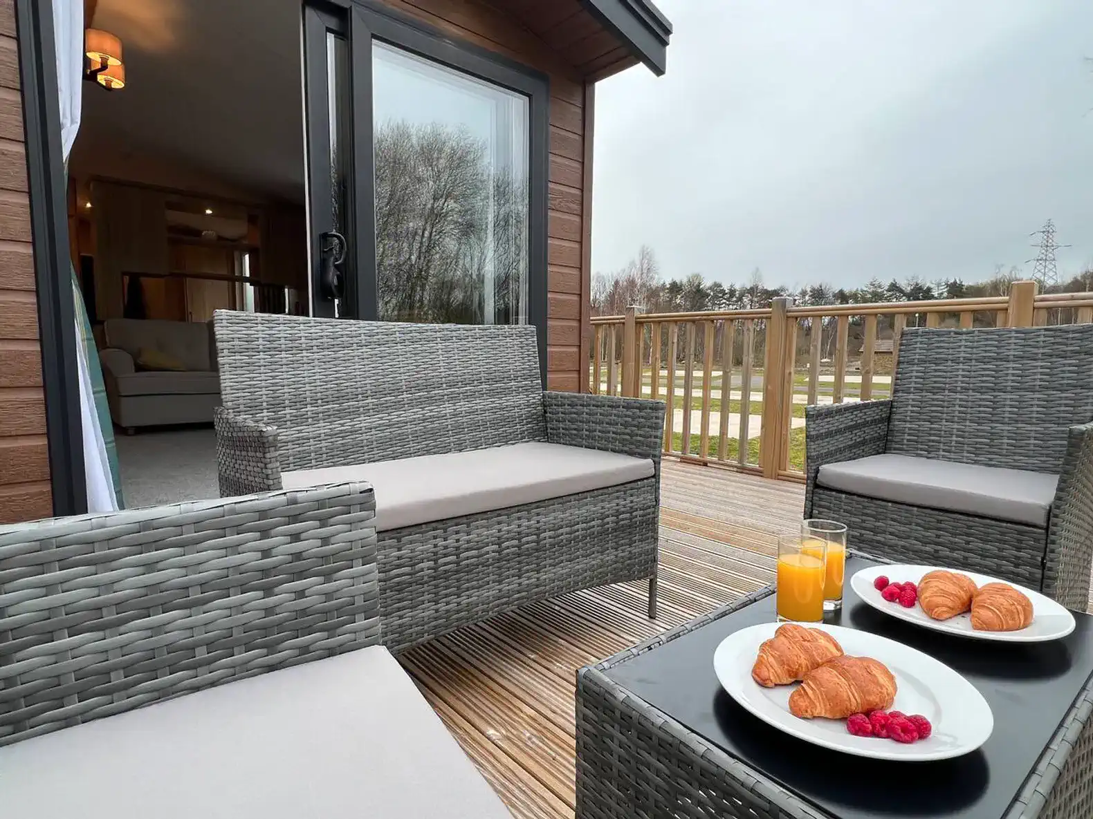 Cozy outdoor seating area with breakfast on a table and a view of the surrounding nature