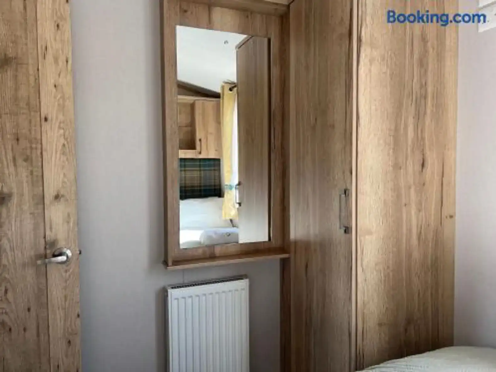 Wooden wardrobe and mirror in a cozy bedroom setting