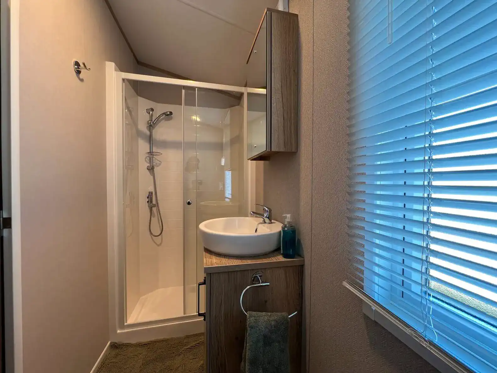 Modern bathroom with shower, sink, and window for natural light