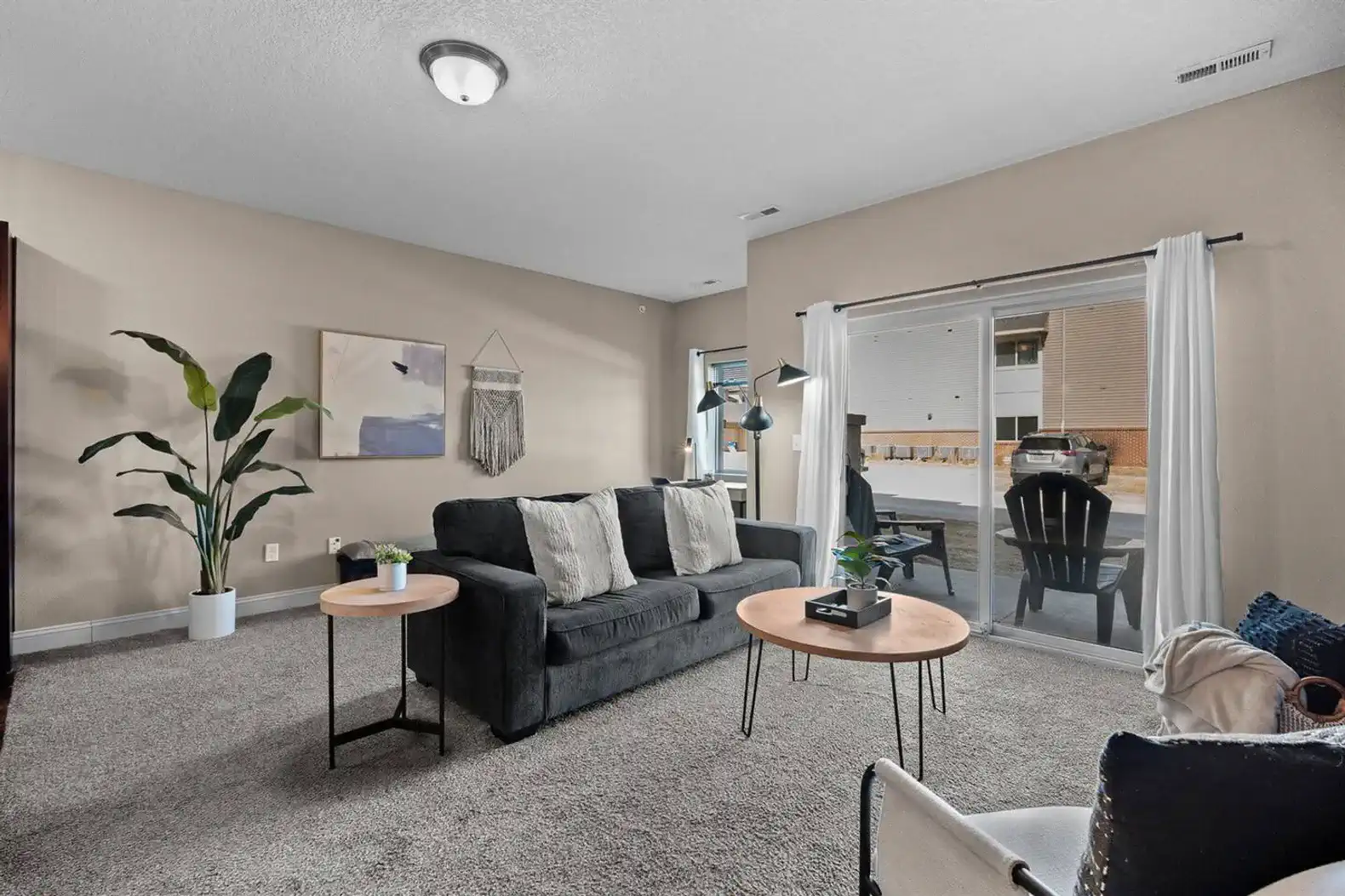 Spacious living room with comfortable seating, natural light, and direct access to the private patio—an easy place to relax, enjoy fresh air, or unwind after a full day.