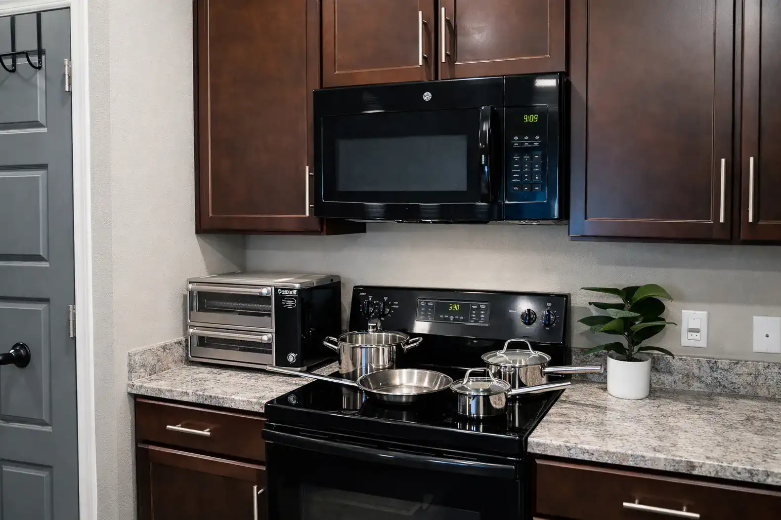 Modern kitchen with cookware, microwave & toaster oven—cook with ease.