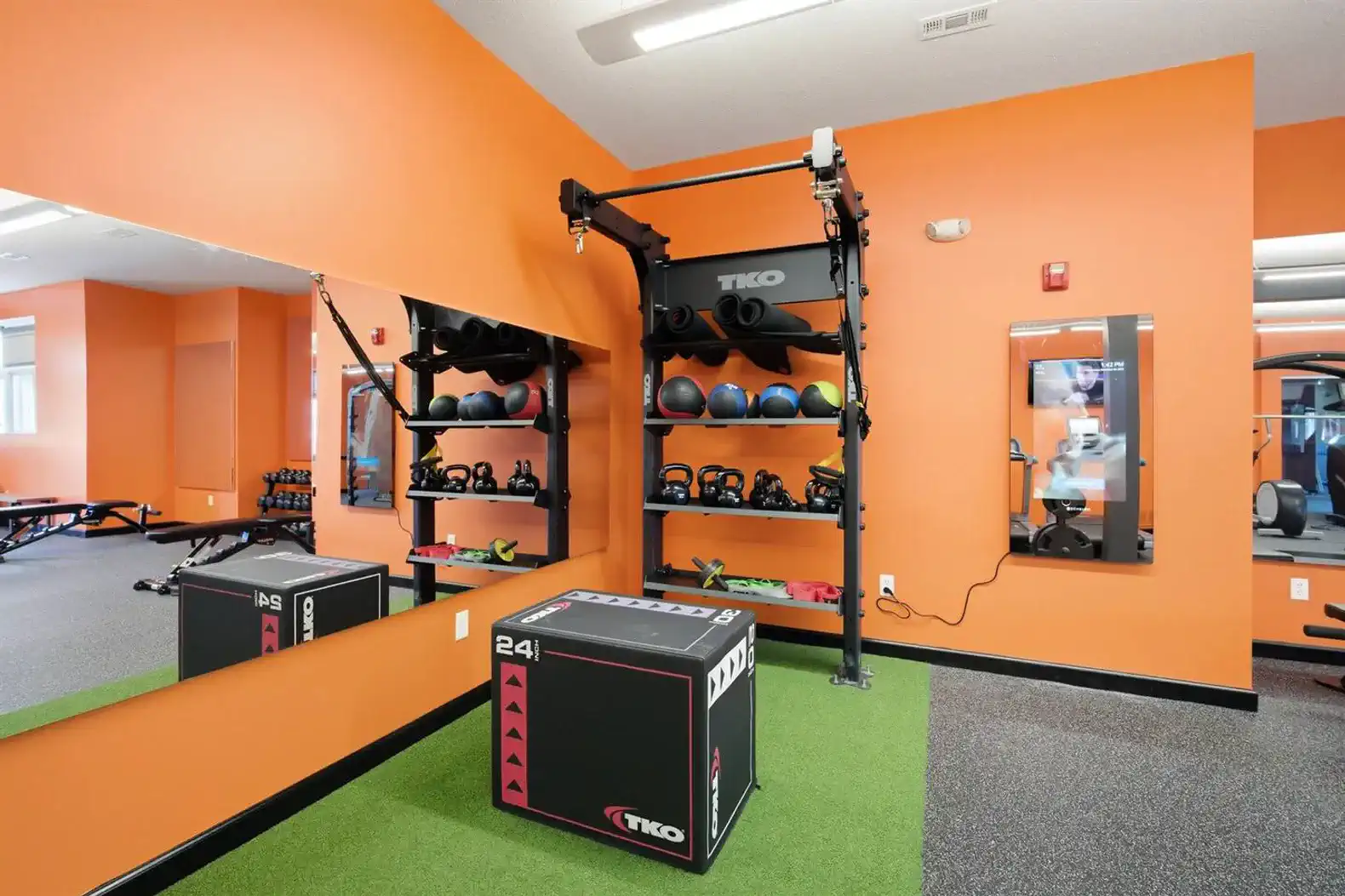 Functional training area with turf flooring, sled equipment, plyometric boxes, and open space for HIIT, stretching, or mobility work.