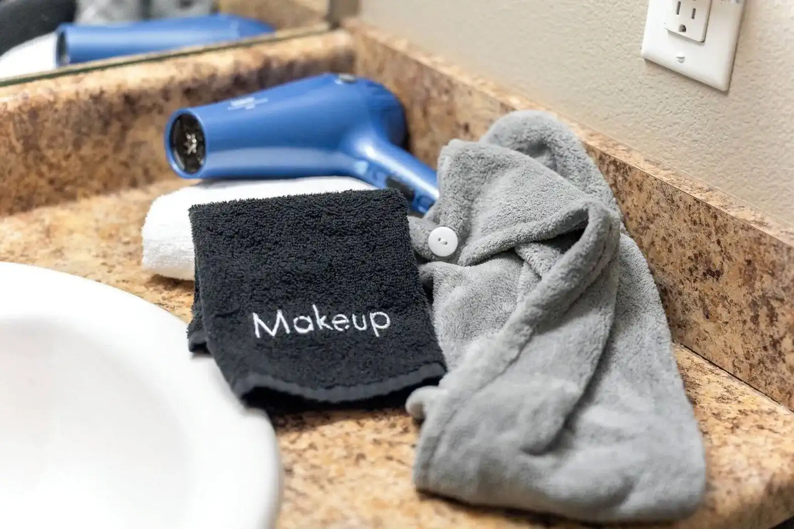 Thoughtful bathroom extras are provided, including makeup removal towels (so your regular towels stay pristine), hair wraps, and a hair dryer—small details that make getting ready easier and help the space feel polished and intentional, not generic.