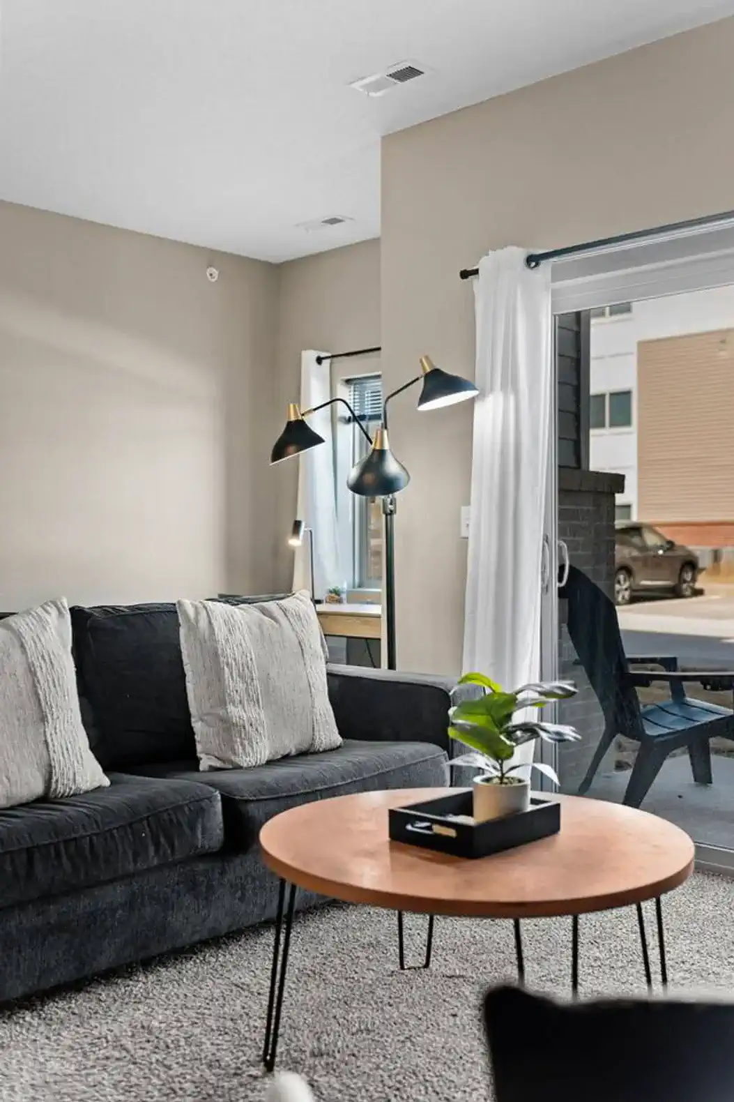 Comfortable living area with soft seating, layered lighting, and direct patio access—perfect for relaxing, enjoying natural light, or easing into the evening indoors or out.