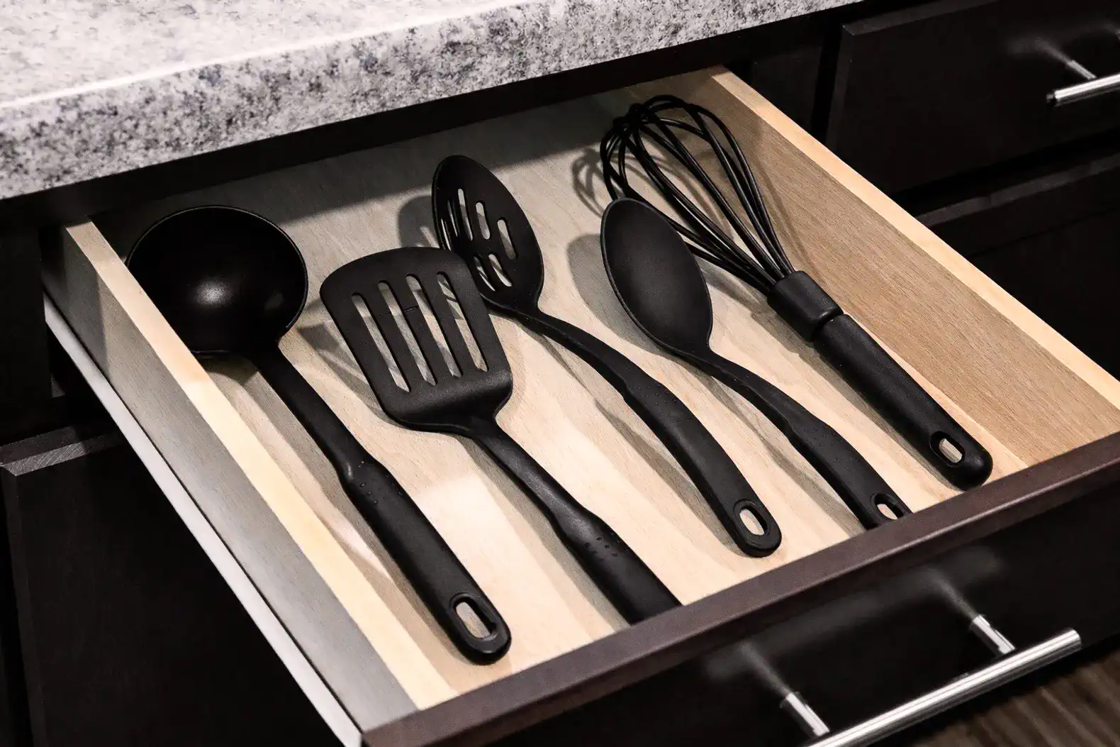 Well-stocked kitchen drawer with sleek utensils—cook with ease.