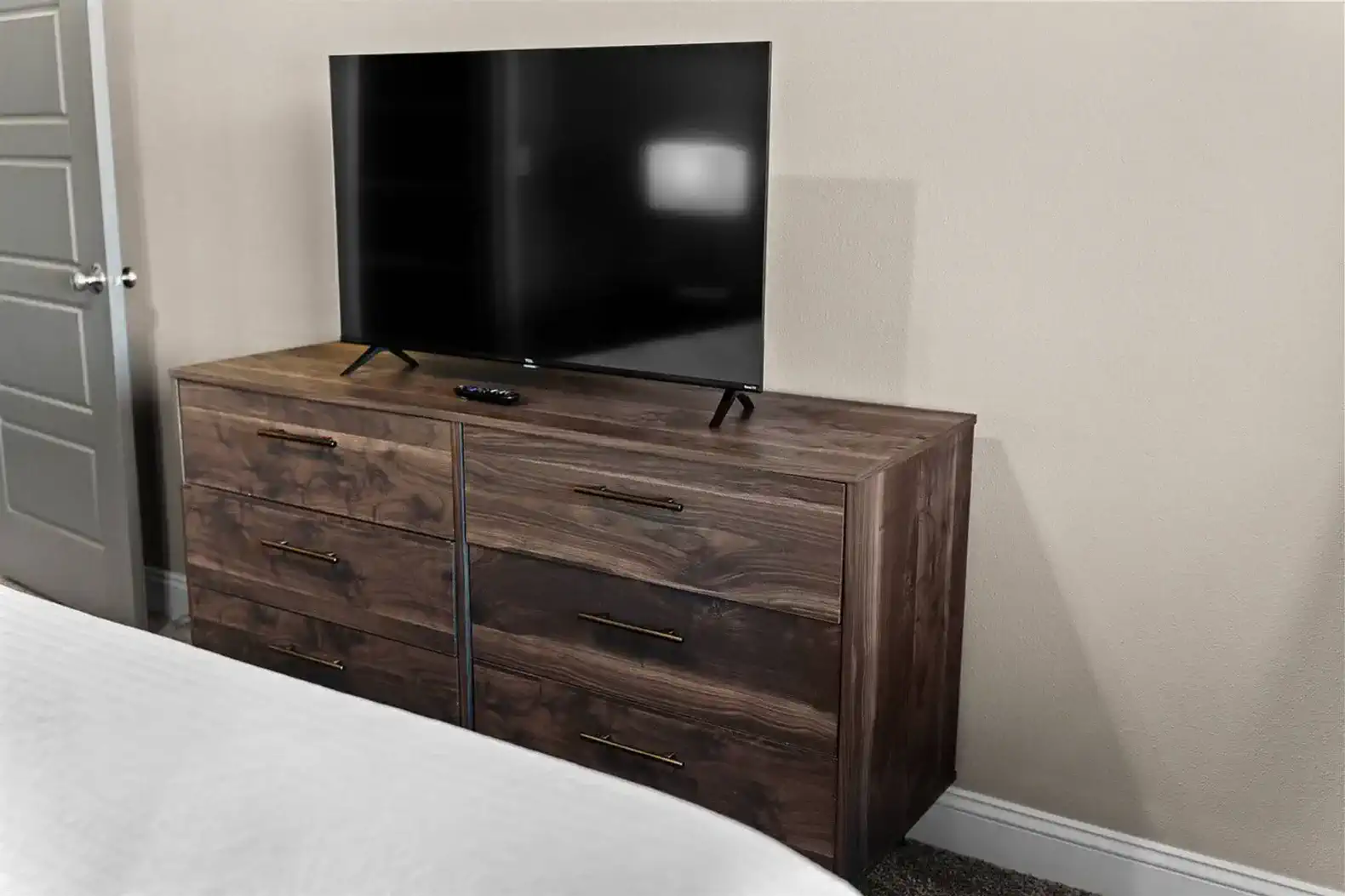 Bedroom dresser with a Smart TV and plenty of storage—perfect for unpacking, settling in, and enjoying easy streaming right from bed.